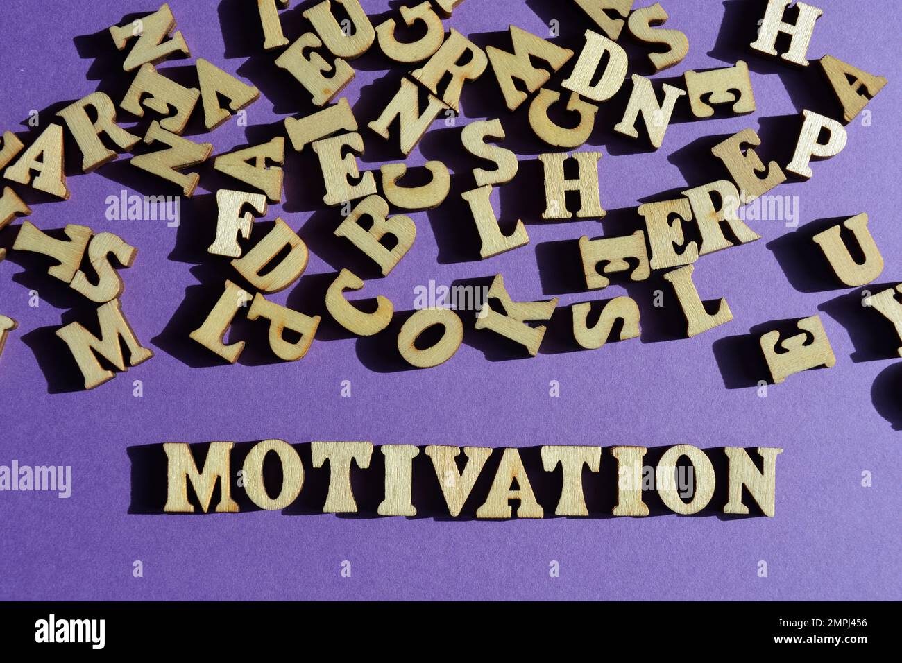 Motivation, mot et lettres aléatoires en bois sur fond violet Banque D'Images