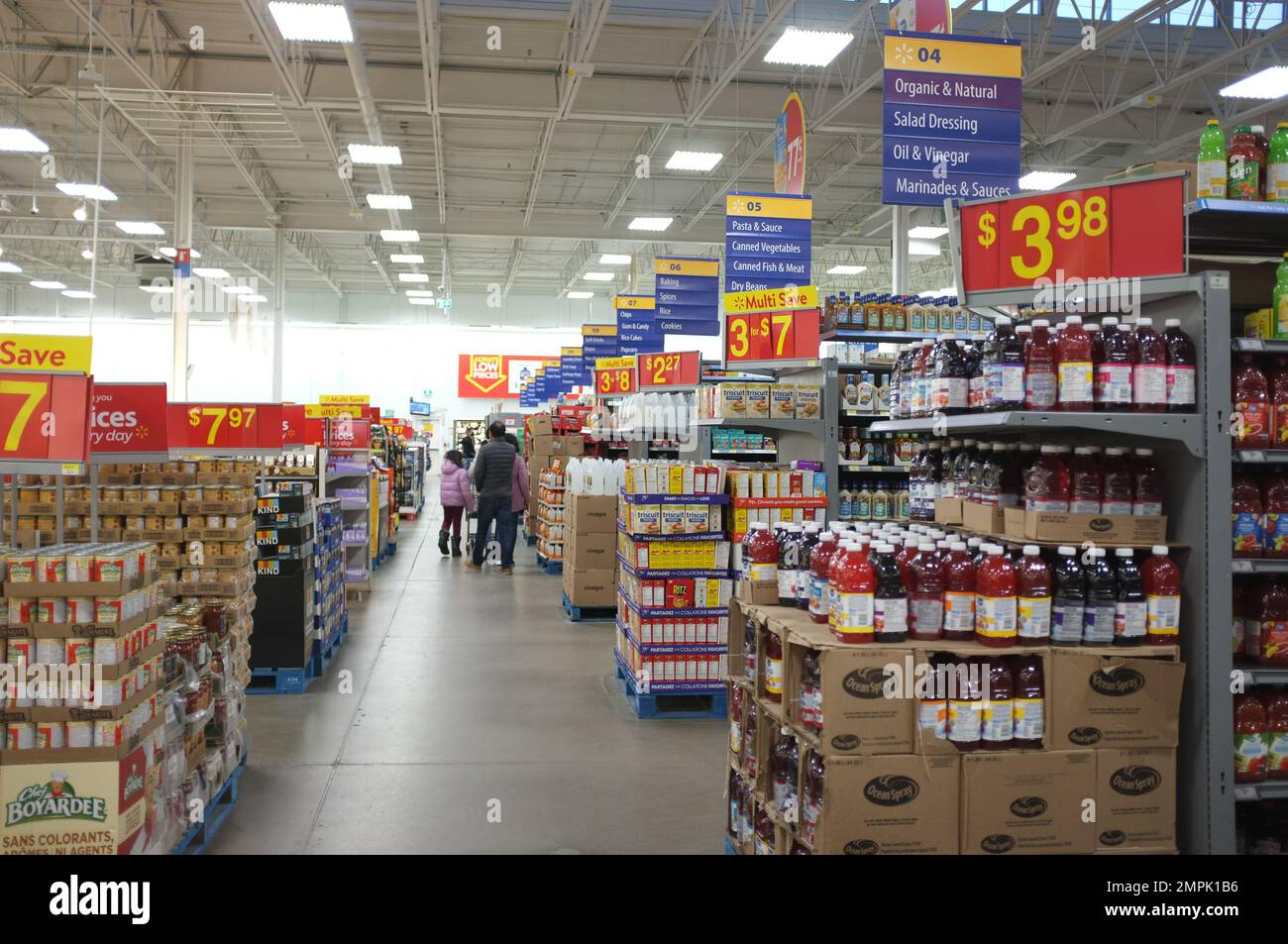 Des bouteilles de jus et des allées d'aliments en conserve dans un magasin Walmart au Canada. Banque D'Images