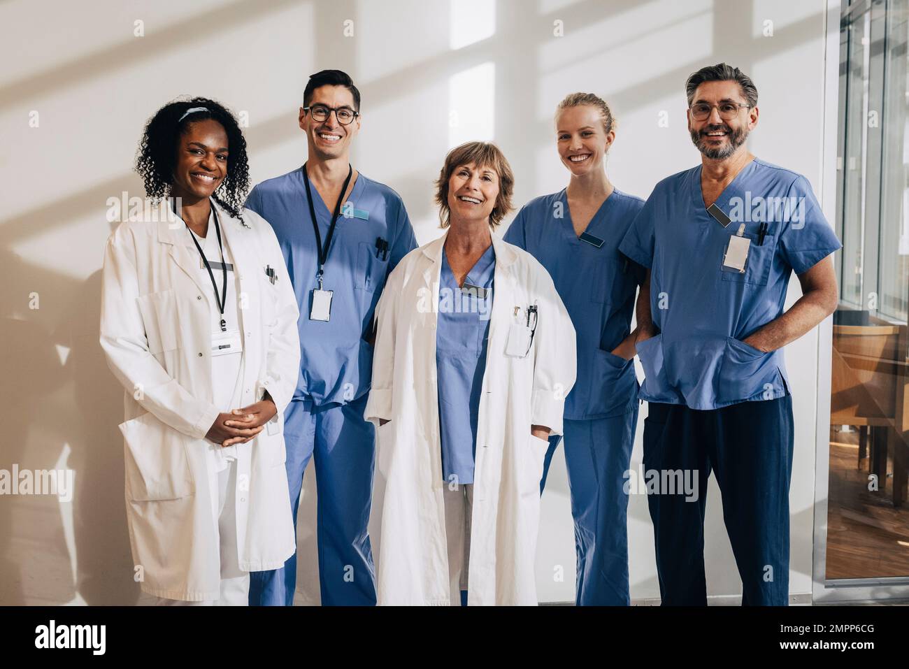 La lumière du soleil tombe sur les professionnels de la santé multiraciale heureux debout à l'hôpital Banque D'Images