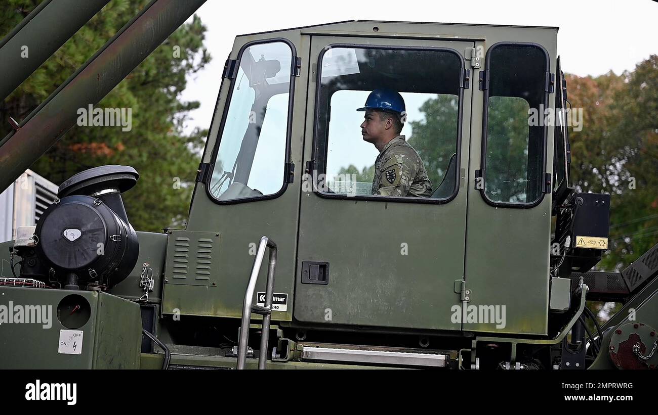 ÉTATS-UNIS Le Sgt Nicholas Luisi, 331st, Compagnie de transport, spécialiste du fret, exploite un chargeur de cargaison en terrain accidenté pour charger des conteneurs de fret sur des wagons de la base commune Langley-Eustis, Virginie, 16 novembre 2022, dans le cadre de l'opération Deep Freeze. Les fournitures à l'intérieur des conteneurs serviront à soutenir les 3 200 scientifiques, chercheurs et personnel de soutien de la station McMurdo, en Antarctique. Banque D'Images