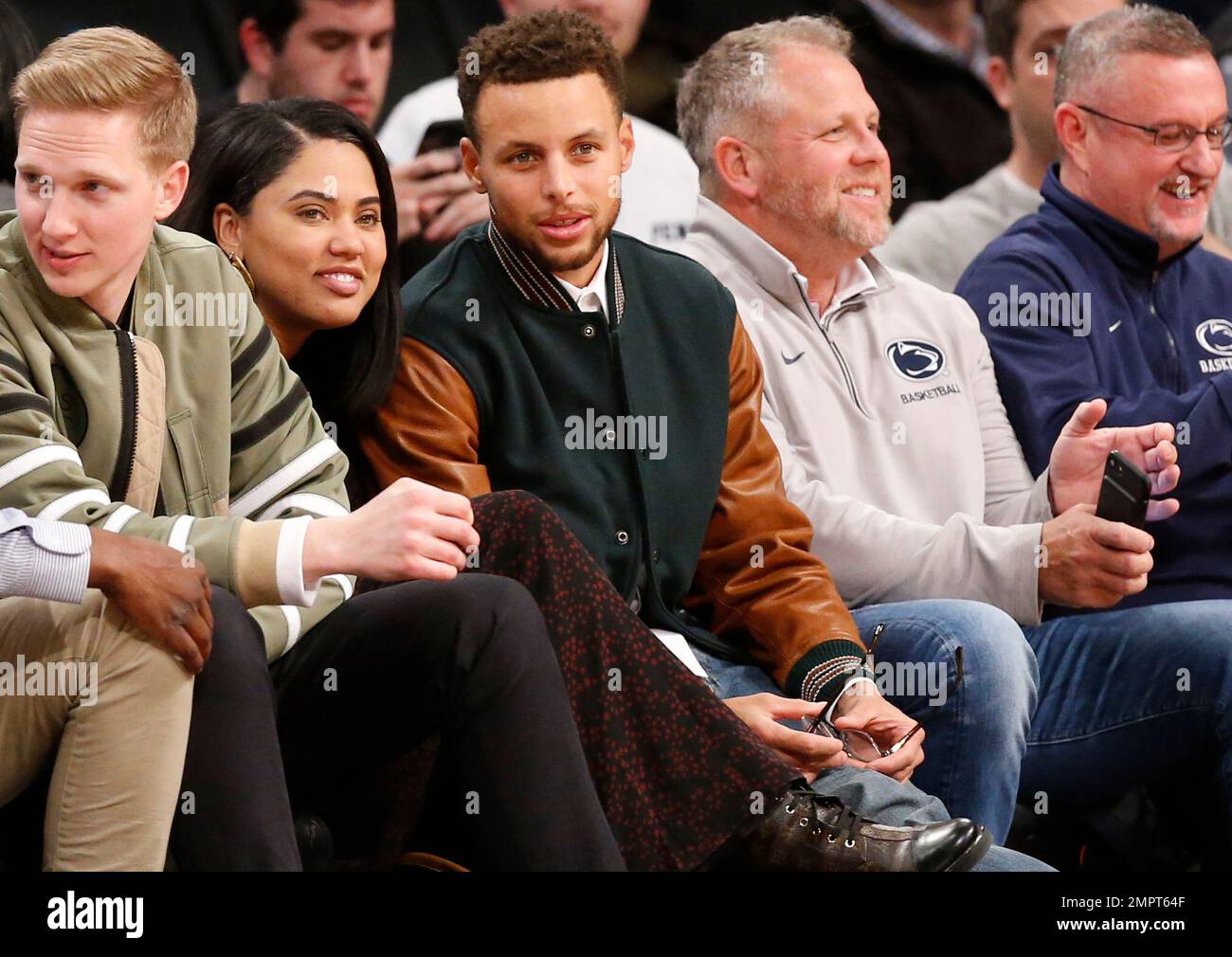 Golden State Warriors guard Stephen Curry, third from left, sits with his wife Ayesha, second from left, as they watch during the second half of an NCAA college basketball game between Penn State and Pittsburgh, Monday, Nov. 20, 2017, in New York. Curry was in New York for a taping of The Tonight Show starring Jimmy Fallon. The Warrriors also played the Brooklyn Nets Sunday night. Social media guru and Curry's Davidson roommate Bryant Barr is at left. (AP Photo/Kathy Willens) Banque D'Images