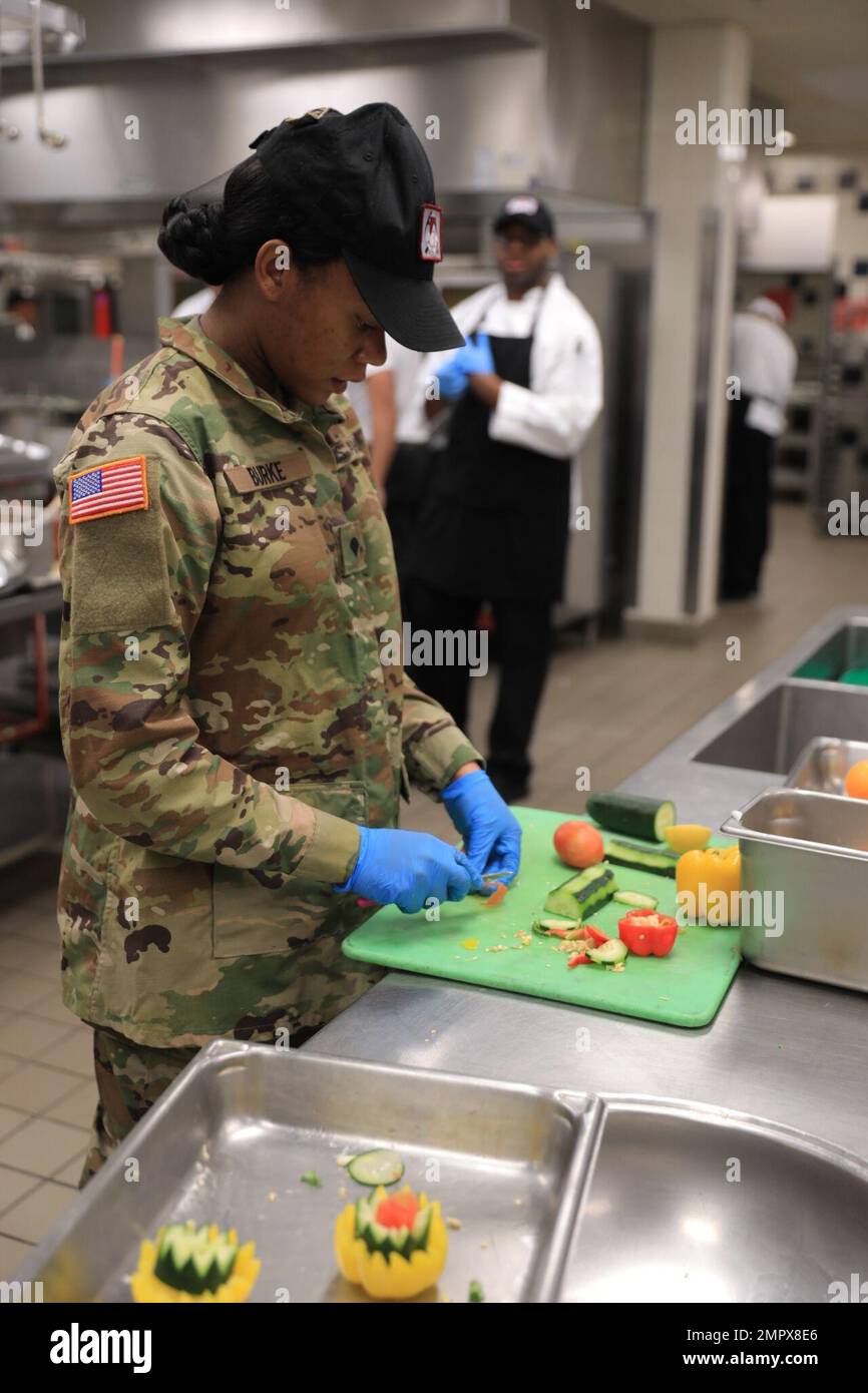 Tiffany Burke, spécialiste culinaire, 1st escadron, 1st Calvary Regiment, 2nd Armored Brigade combat Team, coupe des légumes pour le déjeuner de Thanksgiving au fort Bliss, Texas, Strike Hard Dining Facility le 22 novembre 2022. Des options saines et végétariennes sont toujours proposées dans les salles à manger. Banque D'Images