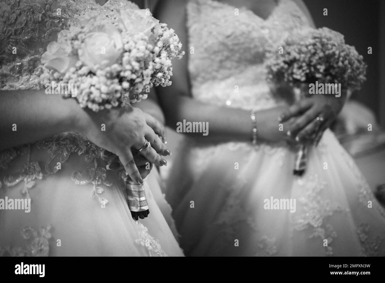 Un cliché monochrome de la mariée debout devant le miroir et tenant un bouquet Banque D'Images