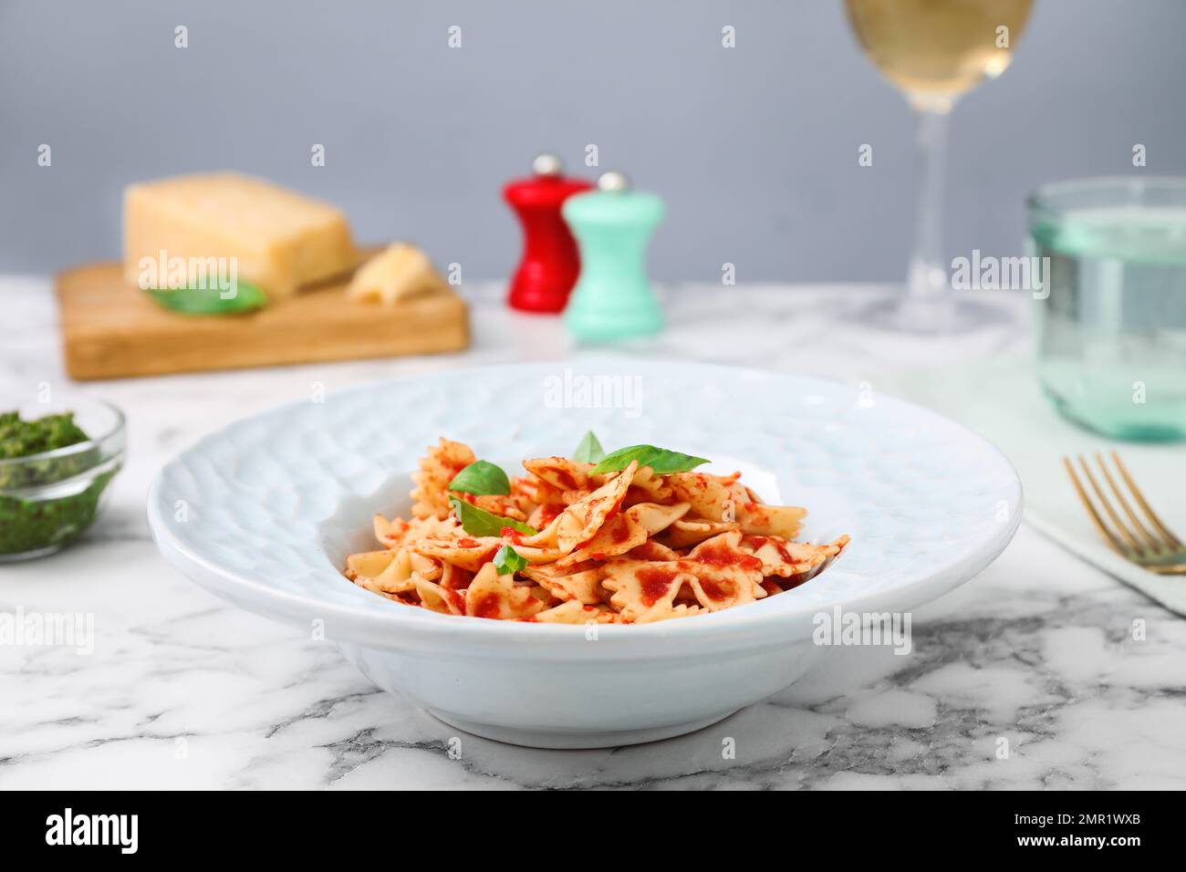Pâtes savoureuses à la sauce tomate et au basilic sur une table en marbre blanc Banque D'Images