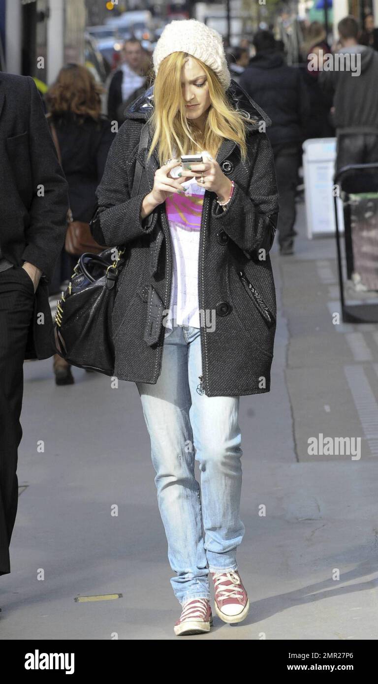Arborant une casquette blanche en laine, un manteau noir, un Jean et un  t-shirt avec des sneakers Converse All-Star roses, Fearne Cotton se  concentre sur son téléphone portable lorsqu'elle quitte la BBC.