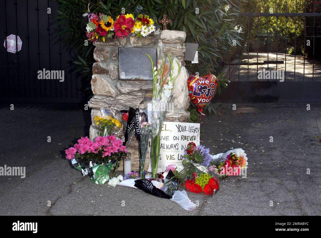 Les fans et les amis se rassemblent à l'extérieur du complexe familial de Jackson pour laisser des fleurs et des cadeaux et rendre hommage à la famille qui arrive du centre médical d'UCLA où Michael Jackson a été déclaré mort après avoir subi un arrêt cardiaque cet après-midi. Encino, Californie 6/25/09. Banque D'Images