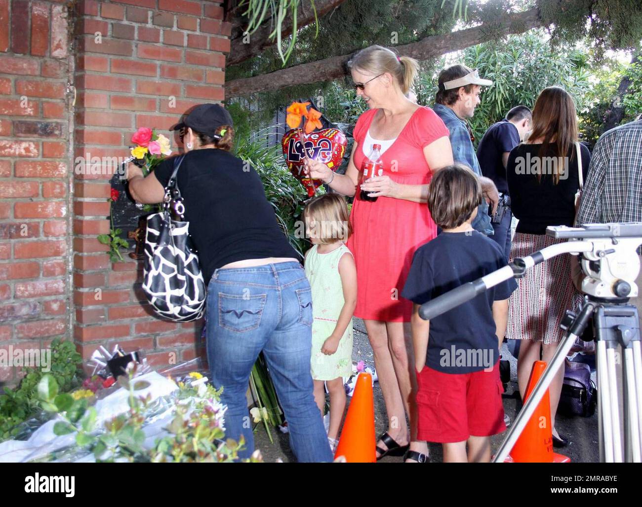 Les fans et les amis se rassemblent à l'extérieur du complexe familial de Jackson pour laisser des fleurs et des cadeaux et rendre hommage à la famille qui arrive du centre médical d'UCLA où Michael Jackson a été déclaré mort après avoir subi un arrêt cardiaque cet après-midi. Encino, Californie 6/25/09. Banque D'Images