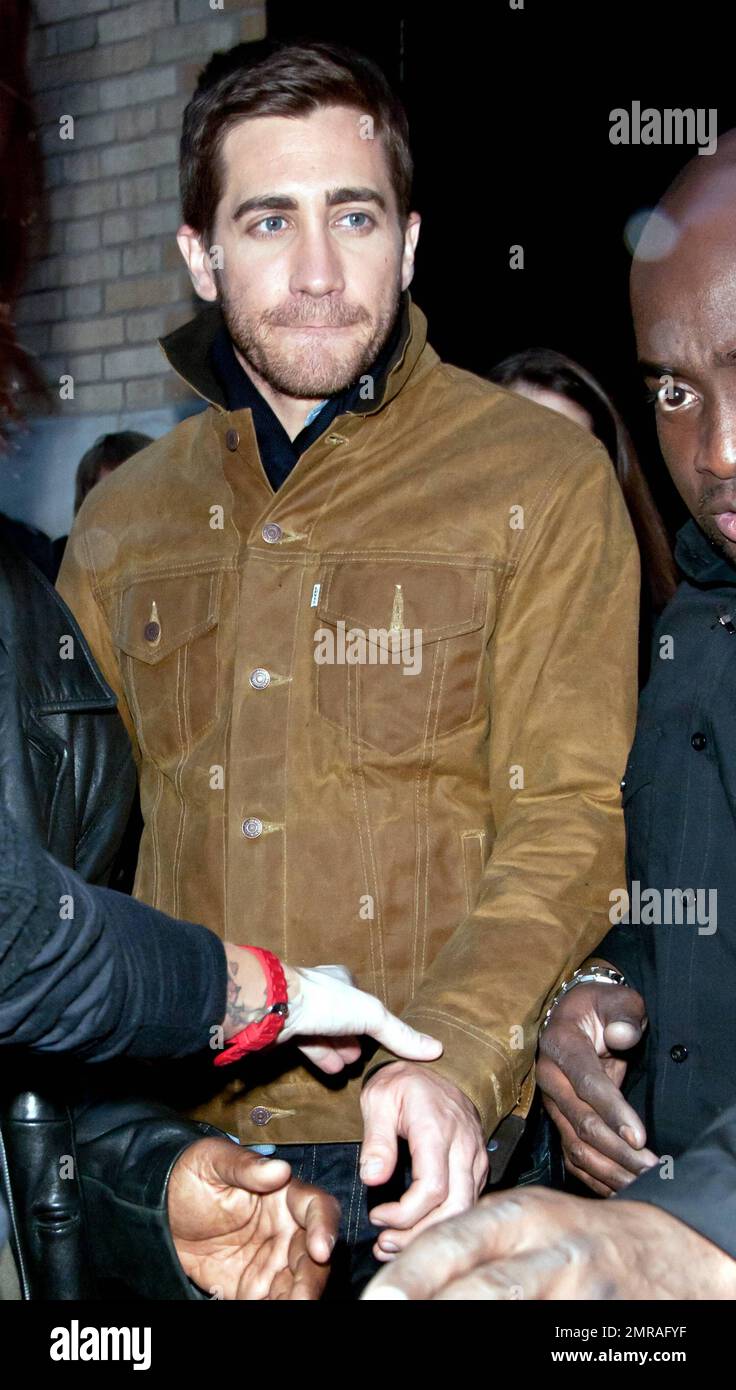 Guidé par des gardes du corps, l'acteur Jake Gyllenhaal arrive à l'Apple Store de Soho à une foule de fans. Gyllenhaal a fait l'apparition dans le magasin pour promouvoir son nouveau thriller « Source Code », qui a été publié aujourd'hui. New York, NY. 4/1/11. Banque D'Images