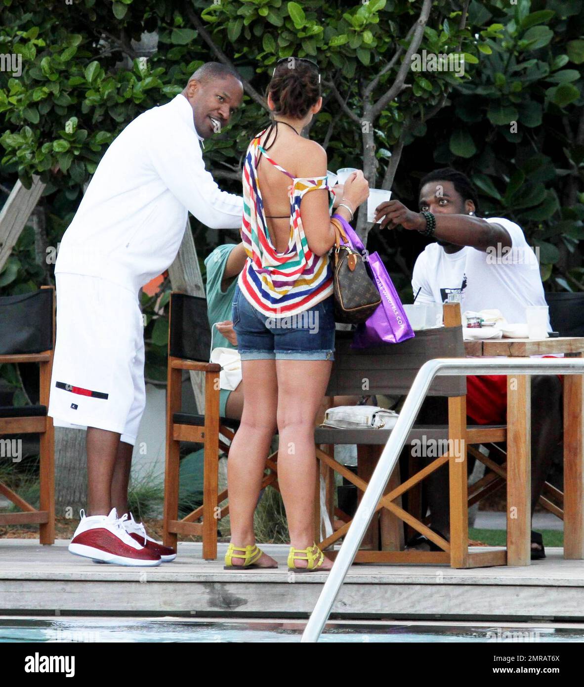 EXCLUSIF !! L'acteur Jamie Foxx a eu ses amis en point de vue lorsqu'il a bavardé avec eux au bord de la piscine dans son hôtel de luxe, avec sa petite amie l'actrice Leila Arcieri, qui portait un haut rayé brillant et un short en denim sur un bikini, à ses côtés. La quartette d'amis, qui semblait juste rencontrer Arcieri, tous ont applaudi et ont fait boire un verre rapide avant de continuer. Avant de se rendre sur leur chemin, Foxx, qui semblait confortable dans un ensemble blanc de vestes, shorts et baskets, a joué au frais et s'est arrêté pour prendre des photos avec plusieurs fans, dont deux étaient de jolies jeunes femmes qu'il a semblé à l'humour comme il a cha Banque D'Images