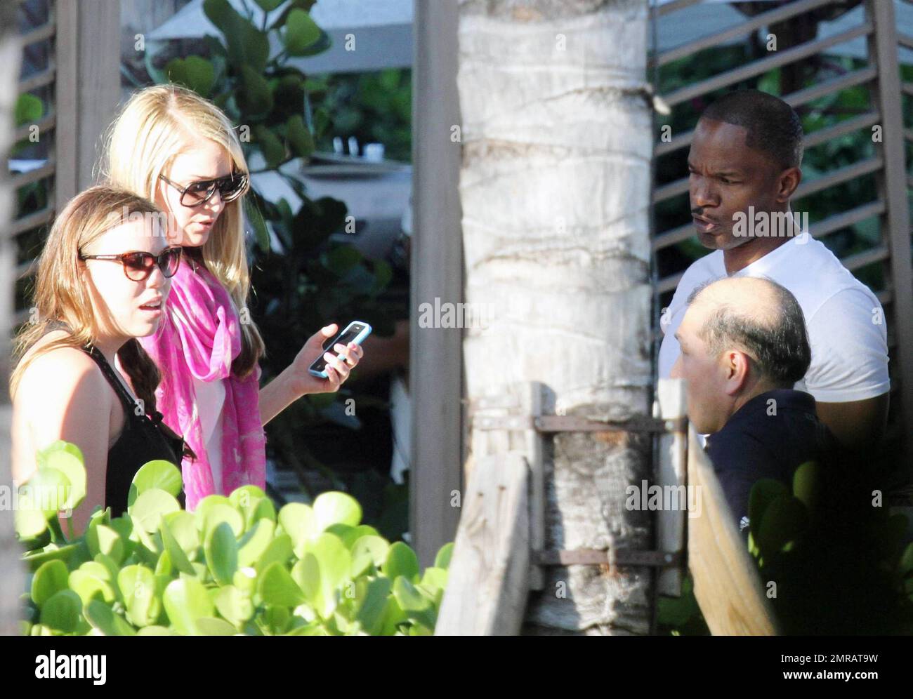 EXCLUSIF !! L'acteur Jamie Foxx a eu ses amis en point de vue lorsqu'il a bavardé avec eux au bord de la piscine dans son hôtel de luxe, avec sa petite amie l'actrice Leila Arcieri, qui portait un haut rayé brillant et un short en denim sur un bikini, à ses côtés. La quartette d'amis, qui semblait juste rencontrer Arcieri, tous ont applaudi et ont fait boire un verre rapide avant de continuer. Avant de se rendre sur leur chemin, Foxx, qui semblait confortable dans un ensemble blanc de vestes, shorts et baskets, a joué au frais et s'est arrêté pour prendre des photos avec plusieurs fans, dont deux étaient de jolies jeunes femmes qu'il a semblé à l'humour comme il a cha Banque D'Images