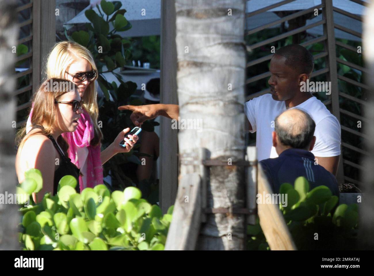 EXCLUSIF !! L'acteur Jamie Foxx a eu ses amis en point de vue lorsqu'il a bavardé avec eux au bord de la piscine dans son hôtel de luxe, avec sa petite amie l'actrice Leila Arcieri, qui portait un haut rayé brillant et un short en denim sur un bikini, à ses côtés. La quartette d'amis, qui semblait juste rencontrer Arcieri, tous ont applaudi et ont fait boire un verre rapide avant de continuer. Avant de se rendre sur leur chemin, Foxx, qui semblait confortable dans un ensemble blanc de vestes, shorts et baskets, a joué au frais et s'est arrêté pour prendre des photos avec plusieurs fans, dont deux étaient de jolies jeunes femmes qu'il a semblé à l'humour comme il a cha Banque D'Images