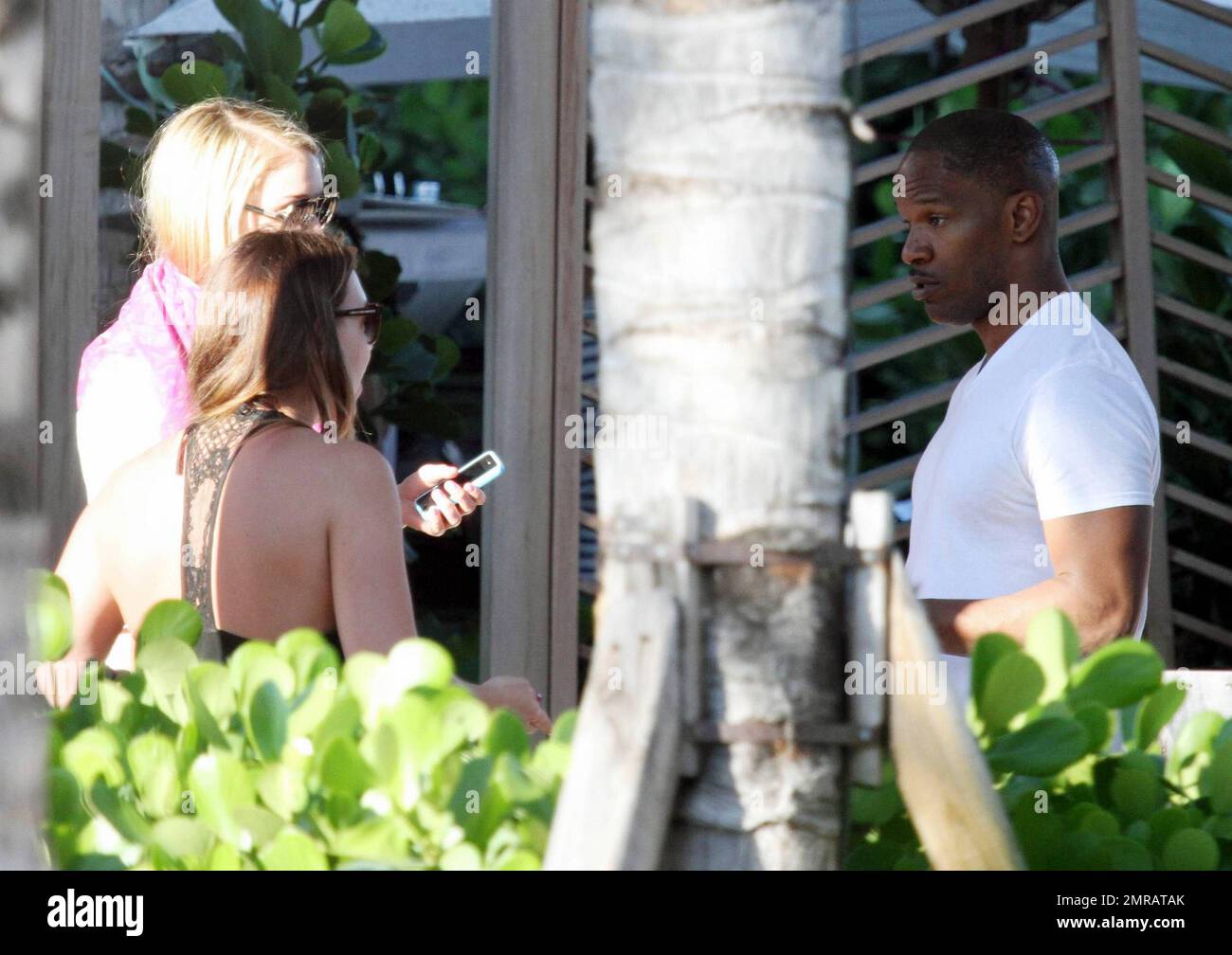 EXCLUSIF !! L'acteur Jamie Foxx a eu ses amis en point de vue lorsqu'il a bavardé avec eux au bord de la piscine dans son hôtel de luxe, avec sa petite amie l'actrice Leila Arcieri, qui portait un haut rayé brillant et un short en denim sur un bikini, à ses côtés. La quartette d'amis, qui semblait juste rencontrer Arcieri, tous ont applaudi et ont fait boire un verre rapide avant de continuer. Avant de se rendre sur leur chemin, Foxx, qui semblait confortable dans un ensemble blanc de vestes, shorts et baskets, a joué au frais et s'est arrêté pour prendre des photos avec plusieurs fans, dont deux étaient de jolies jeunes femmes qu'il a semblé à l'humour comme il a cha Banque D'Images