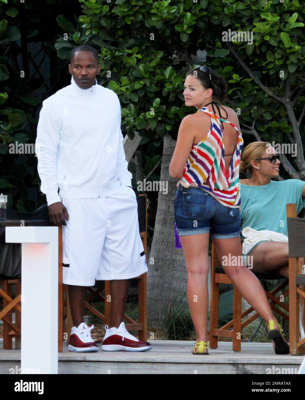 EXCLUSIF !! L'acteur Jamie Foxx a eu ses amis en point de vue lorsqu'il a bavardé avec eux au bord de la piscine dans son hôtel de luxe, avec sa petite amie l'actrice Leila Arcieri, qui portait un haut rayé brillant et un short en denim sur un bikini, à ses côtés. La quartette d'amis, qui semblait juste rencontrer Arcieri, tous ont applaudi et ont fait boire un verre rapide avant de continuer. Avant de se rendre sur leur chemin, Foxx, qui semblait confortable dans un ensemble blanc de vestes, shorts et baskets, a joué au frais et s'est arrêté pour prendre des photos avec plusieurs fans, dont deux étaient de jolies jeunes femmes qu'il a semblé à l'humour comme il a cha Banque D'Images
