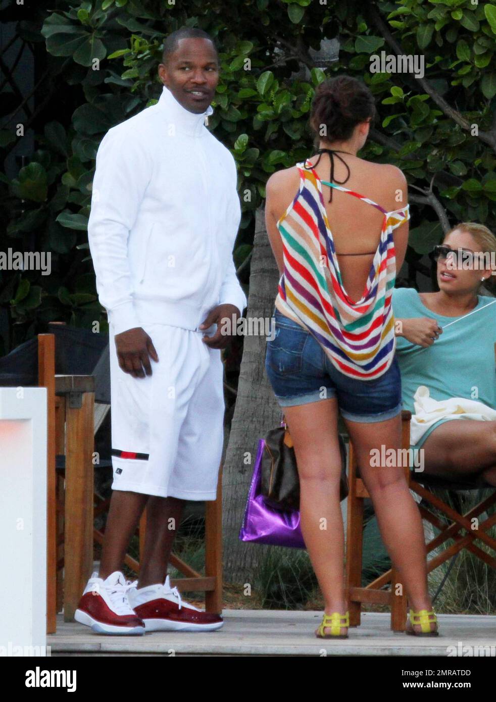 EXCLUSIF !! L'acteur Jamie Foxx a eu ses amis en point de vue lorsqu'il a bavardé avec eux au bord de la piscine dans son hôtel de luxe, avec sa petite amie l'actrice Leila Arcieri, qui portait un haut rayé brillant et un short en denim sur un bikini, à ses côtés. La quartette d'amis, qui semblait juste rencontrer Arcieri, tous ont applaudi et ont fait boire un verre rapide avant de continuer. Avant de se rendre sur leur chemin, Foxx, qui semblait confortable dans un ensemble blanc de vestes, shorts et baskets, a joué au frais et s'est arrêté pour prendre des photos avec plusieurs fans, dont deux étaient de jolies jeunes femmes qu'il a semblé à l'humour comme il a cha Banque D'Images