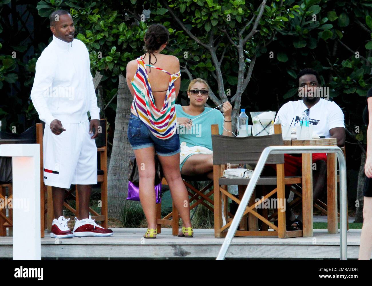 EXCLUSIF !! L'acteur Jamie Foxx a eu ses amis en point de vue lorsqu'il a bavardé avec eux au bord de la piscine dans son hôtel de luxe, avec sa petite amie l'actrice Leila Arcieri, qui portait un haut rayé brillant et un short en denim sur un bikini, à ses côtés. La quartette d'amis, qui semblait juste rencontrer Arcieri, tous ont applaudi et ont fait boire un verre rapide avant de continuer. Avant de se rendre sur leur chemin, Foxx, qui semblait confortable dans un ensemble blanc de vestes, shorts et baskets, a joué au frais et s'est arrêté pour prendre des photos avec plusieurs fans, dont deux étaient de jolies jeunes femmes qu'il a semblé à l'humour comme il a cha Banque D'Images
