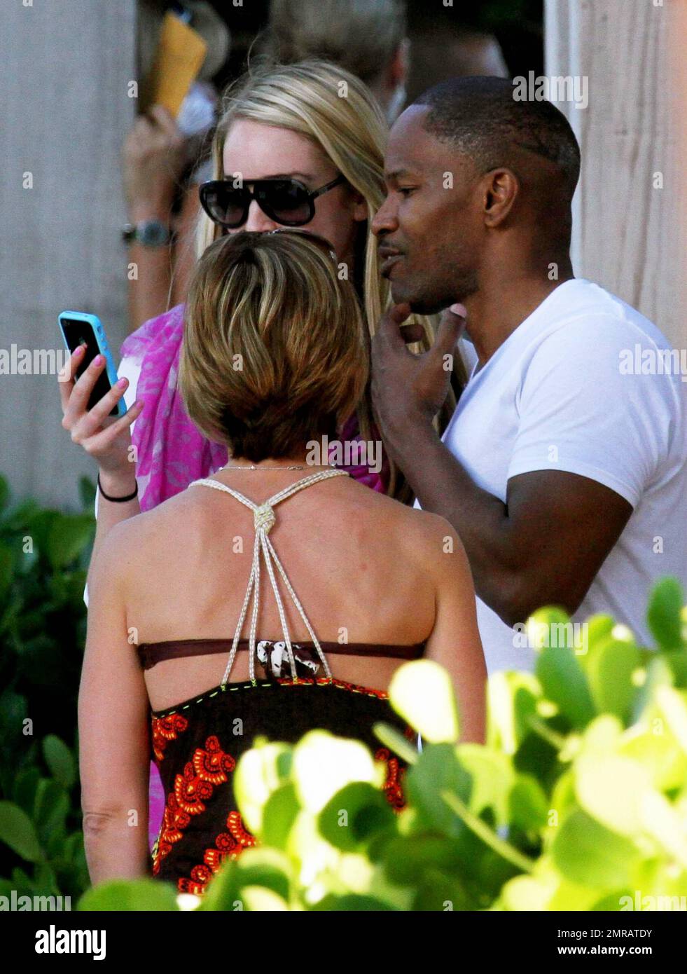 EXCLUSIF !! L'acteur Jamie Foxx a eu ses amis en point de vue lorsqu'il a bavardé avec eux au bord de la piscine dans son hôtel de luxe, avec sa petite amie l'actrice Leila Arcieri, qui portait un haut rayé brillant et un short en denim sur un bikini, à ses côtés. La quartette d'amis, qui semblait juste rencontrer Arcieri, tous ont applaudi et ont fait boire un verre rapide avant de continuer. Avant de se rendre sur leur chemin, Foxx, qui semblait confortable dans un ensemble blanc de vestes, shorts et baskets, a joué au frais et s'est arrêté pour prendre des photos avec plusieurs fans, dont deux étaient de jolies jeunes femmes qu'il a semblé à l'humour comme il a cha Banque D'Images
