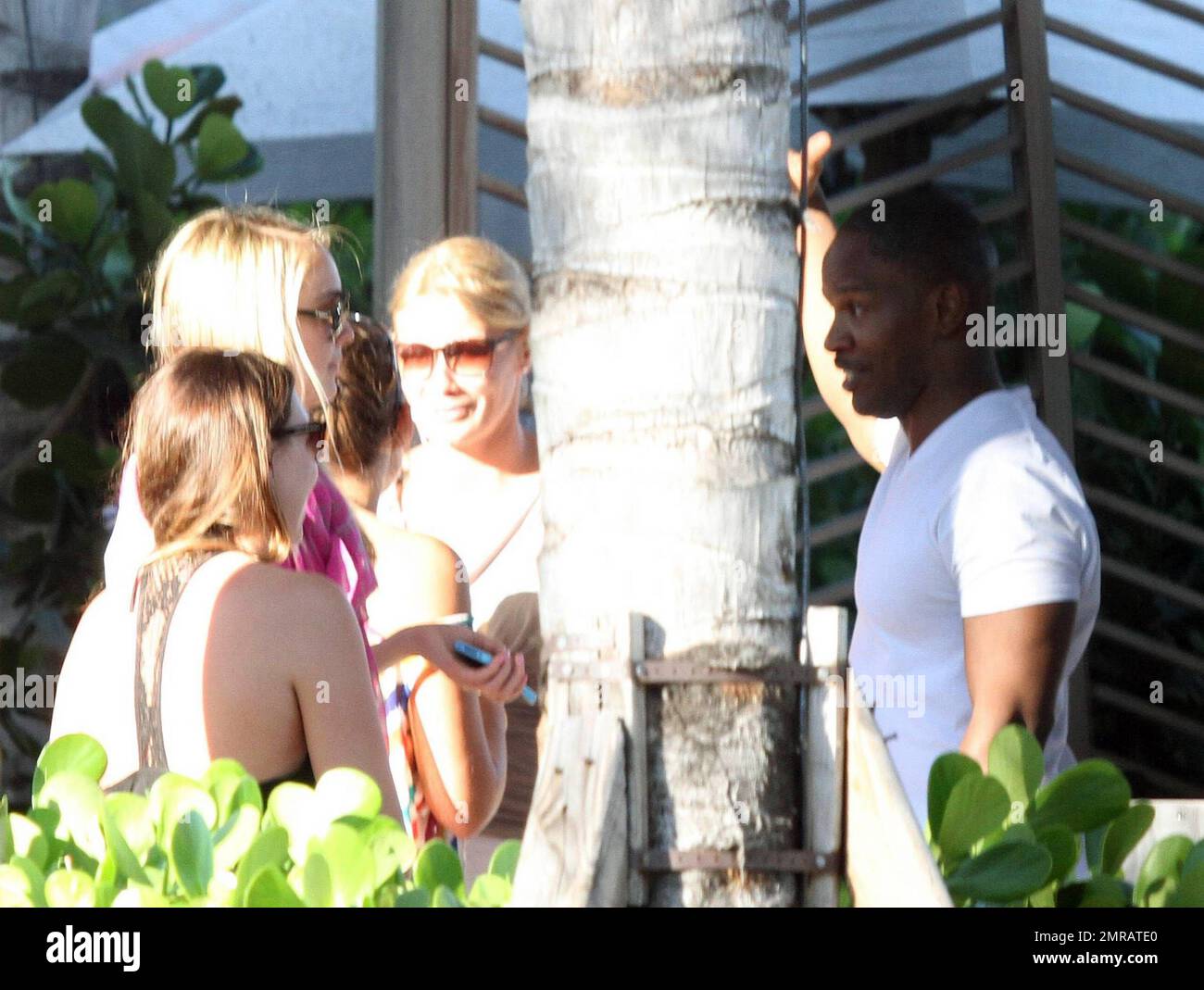 EXCLUSIF !! L'acteur Jamie Foxx a eu ses amis en point de vue lorsqu'il a bavardé avec eux au bord de la piscine dans son hôtel de luxe, avec sa petite amie l'actrice Leila Arcieri, qui portait un haut rayé brillant et un short en denim sur un bikini, à ses côtés. La quartette d'amis, qui semblait juste rencontrer Arcieri, tous ont applaudi et ont fait boire un verre rapide avant de continuer. Avant de se rendre sur leur chemin, Foxx, qui semblait confortable dans un ensemble blanc de vestes, shorts et baskets, a joué au frais et s'est arrêté pour prendre des photos avec plusieurs fans, dont deux étaient de jolies jeunes femmes qu'il a semblé à l'humour comme il a cha Banque D'Images