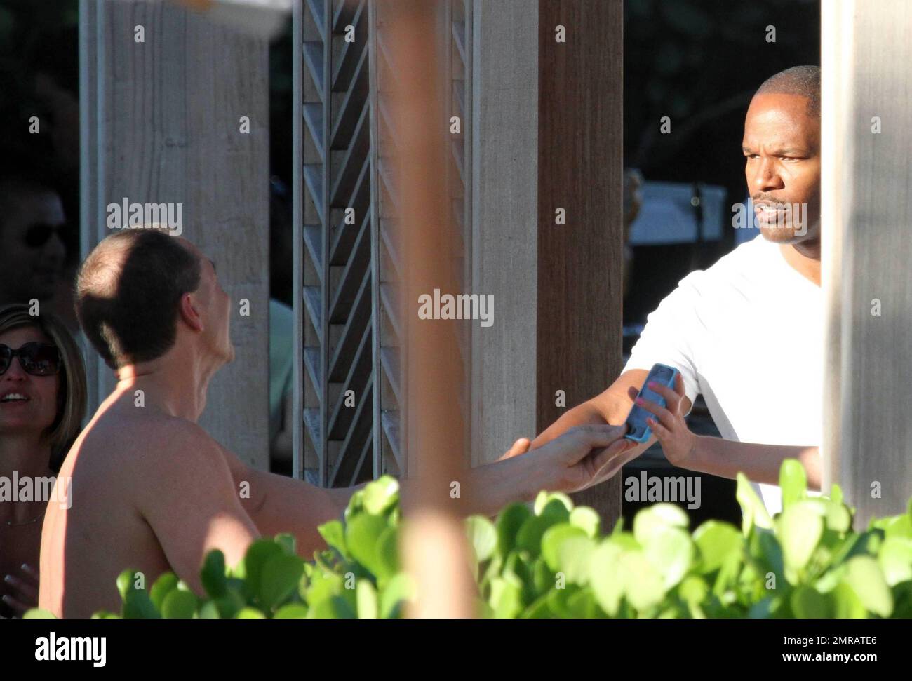 EXCLUSIF !! L'acteur Jamie Foxx a eu ses amis en point de vue lorsqu'il a bavardé avec eux au bord de la piscine dans son hôtel de luxe, avec sa petite amie l'actrice Leila Arcieri, qui portait un haut rayé brillant et un short en denim sur un bikini, à ses côtés. La quartette d'amis, qui semblait juste rencontrer Arcieri, tous ont applaudi et ont fait boire un verre rapide avant de continuer. Avant de se rendre sur leur chemin, Foxx, qui semblait confortable dans un ensemble blanc de vestes, shorts et baskets, a joué au frais et s'est arrêté pour prendre des photos avec plusieurs fans, dont deux étaient de jolies jeunes femmes qu'il a semblé à l'humour comme il a cha Banque D'Images