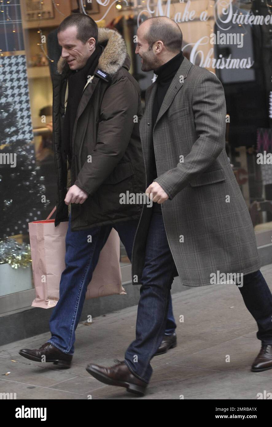 Avec un grand sourire sur son visage, Jason Statham, star de l'action,  avait l'air d'être plutôt moche dans une veste taillée, un pull à col  roulé, un Jean et des chaussures habillées