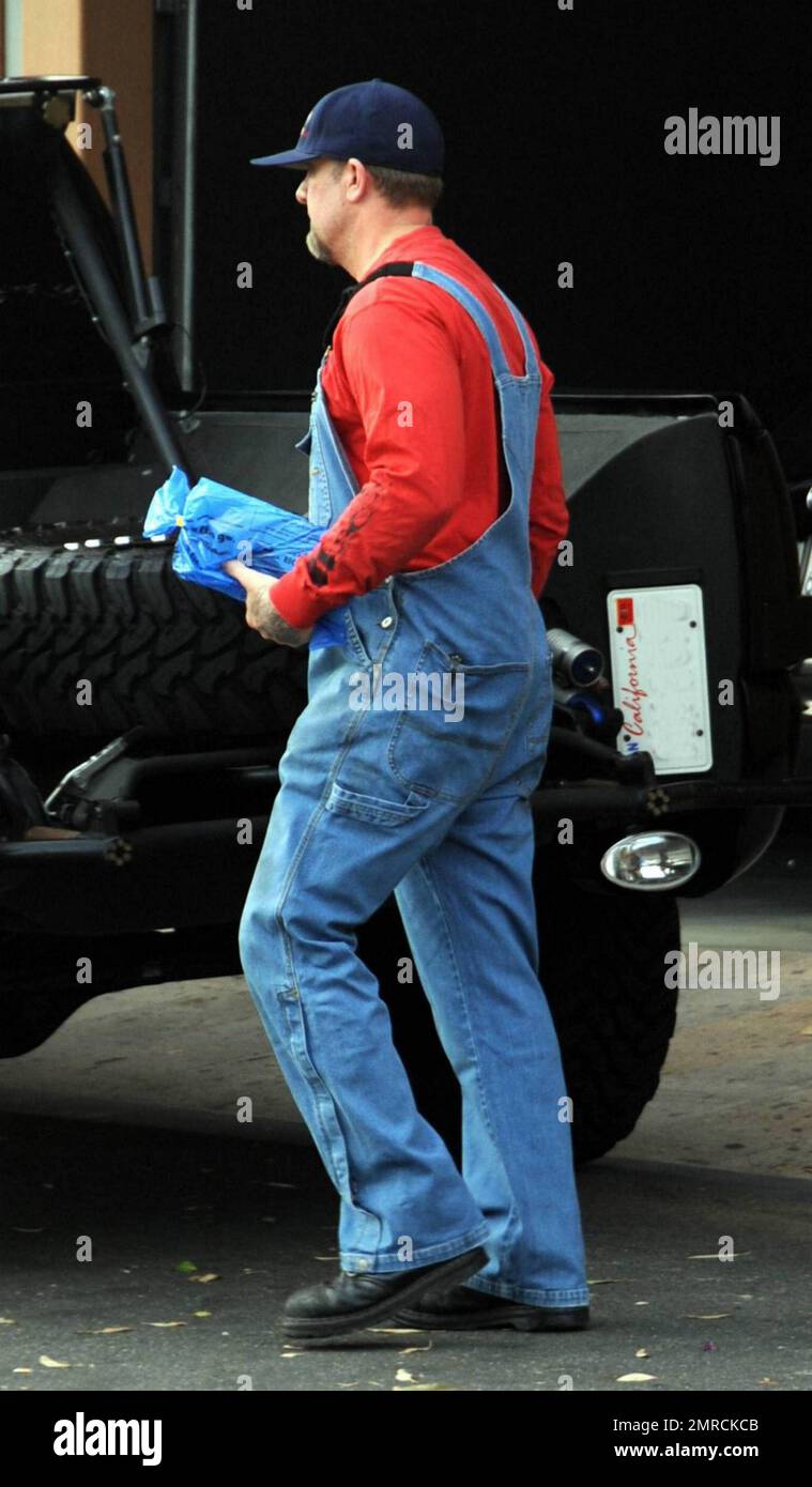 Jesse James quitte sa maison ce matin vêtu pour le travail dans une paire  de salopettes en denim et une casquette de baseball. Bien que son épouse,  Sandra Bullock, ait quitté la