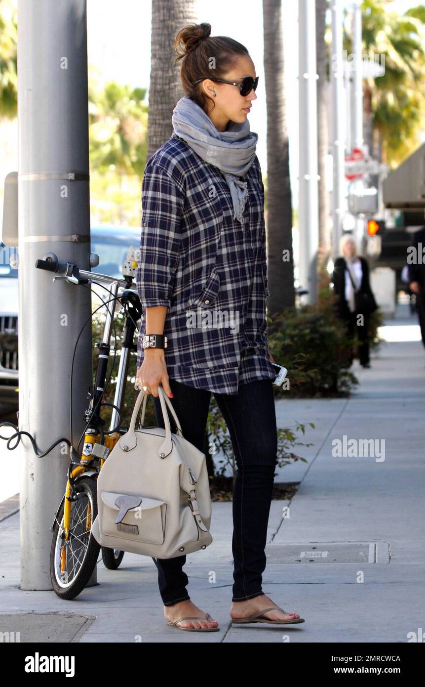 L'actrice Jessica Alba se rend décontractée dans une chemise à carreaux,  une écharpe grise, un pantalon noir et des tongs, car elle paie pour se  garer à un mètre de distance pendant