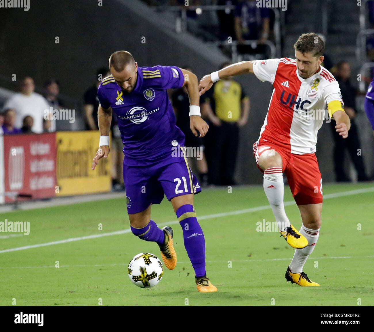 Orlando City's Scott Sutter (21) and New England Revolution's Chris Tierney, right, battle for possession of the ball during the first half of an MLS soccer match, Wednesday, Sept. 27, 2017, in Orlando, Fla. (AP Photo/John Raoux) Banque D'Images