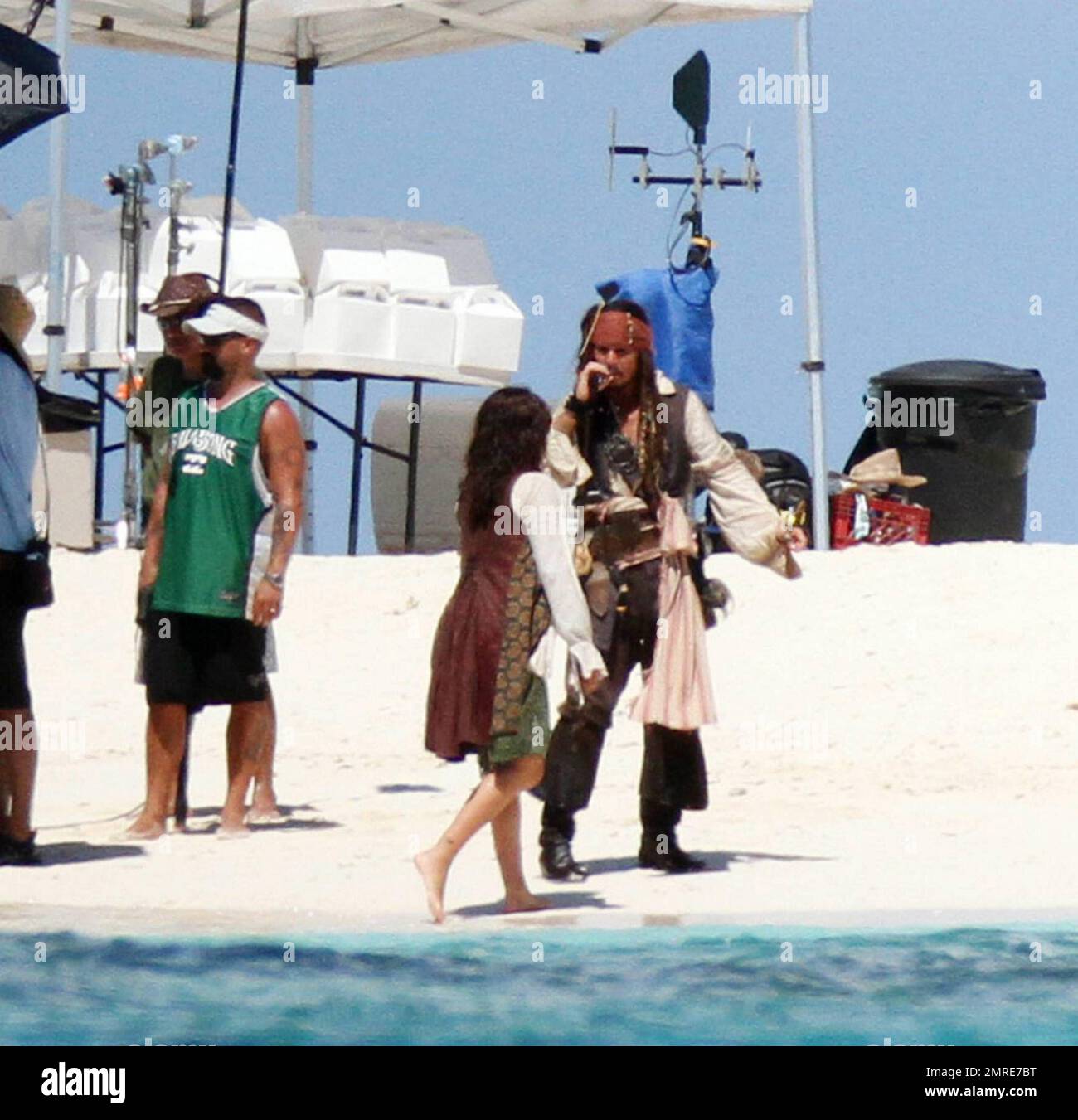 EXCLUSIF !! Johnny Depp a une cigarette alors qu'il filme une scène avec Penelope Cruz sur une île déserte pour la suite Disney à venir "Pirates des Caraïbes: On Stranger Tides". Depp, était entièrement en costume et en maquillage du capitaine Jack Sparrow. Cruz, portant une robe blanche fluide, un pantalon noir et un gilet a montré une figure beaucoup plus grande que la normale au milieu des rumeurs de grossesse. Dans le quatrième épisode de Pirates, le capitaine Jack Sparrow (Depp) traverse des chemins avec Angelica, une femme de son passé (Cruz), et il n'est pas sûr si c'est de l'amour, ou si elle est un artiste impitoyable qui l'utilise pour trouver le fou Banque D'Images