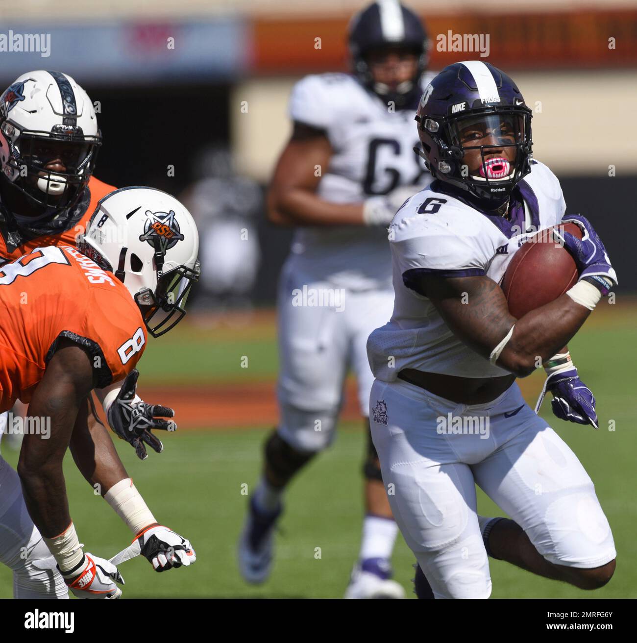 TCU running back Darius Anderson, right, break away from Oklahoma State defensive end Tralund Webber, left, and safety Za'Carrius Green to score a touchdown during the first half of an NCAA college football game in Stillwater, Okla., Saturday, Sept. 23, 2017.(AP Photo/Brody Schmidt) Banque D'Images