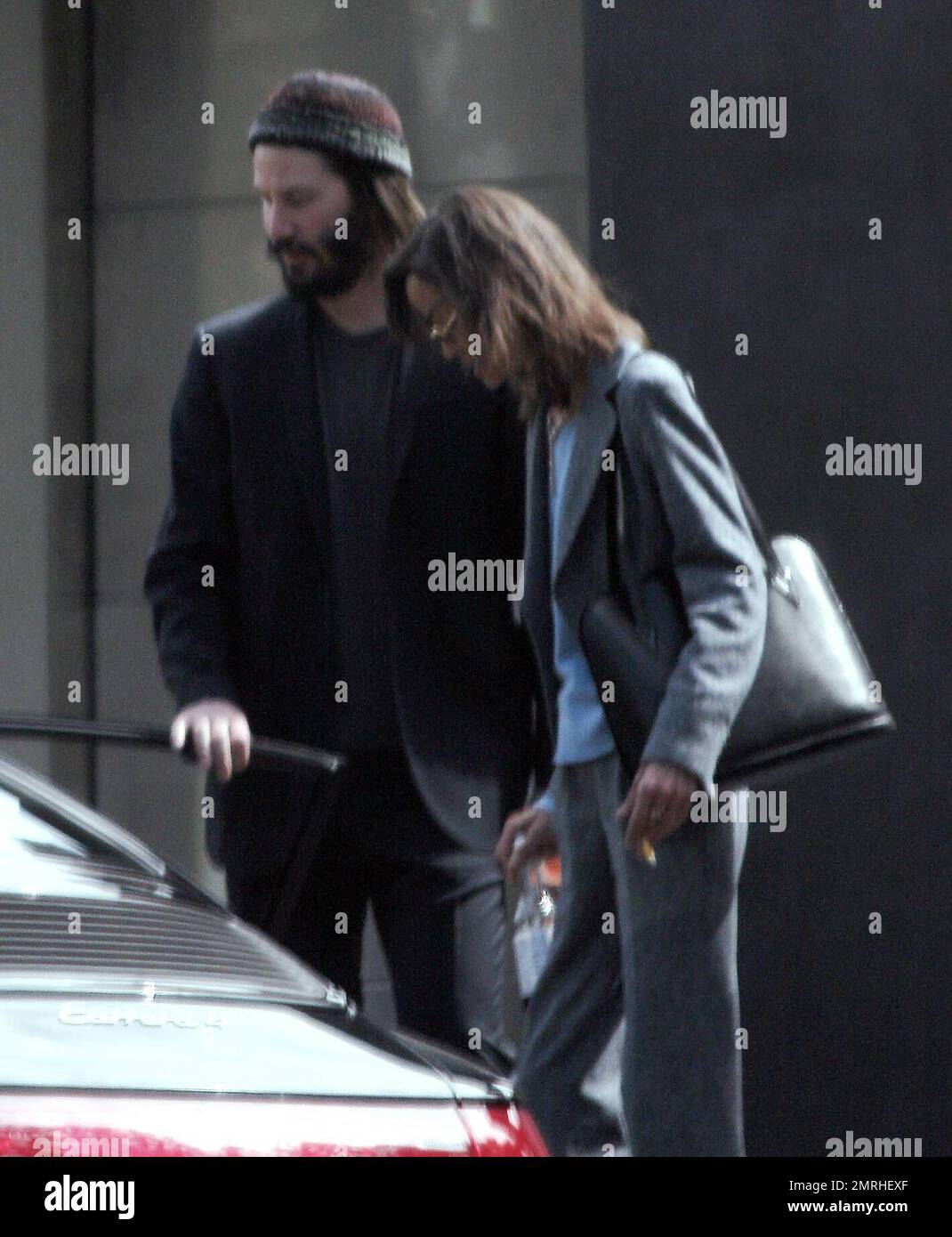 Exclusif !! Un regard triste Keanu Reeves ouvre la porte d'une voiture pour une femme compagnon après une visite de sa maison de Hollywood Hills à CA. L'acteur a montré à la femme en train de regarder les rénovations qu'il a fait à sa maison de style moderne depuis plusieurs mois. 3/4/07 Banque D'Images