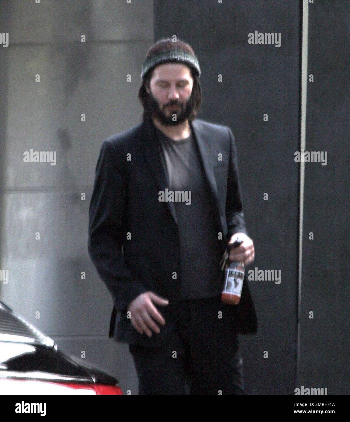 Exclusif !! Un regard triste Keanu Reeves ouvre la porte d'une voiture pour une femme compagnon après une visite de sa maison de Hollywood Hills à CA. L'acteur a montré à la femme en train de regarder les rénovations qu'il a fait à sa maison de style moderne depuis plusieurs mois. 3/4/07 Banque D'Images