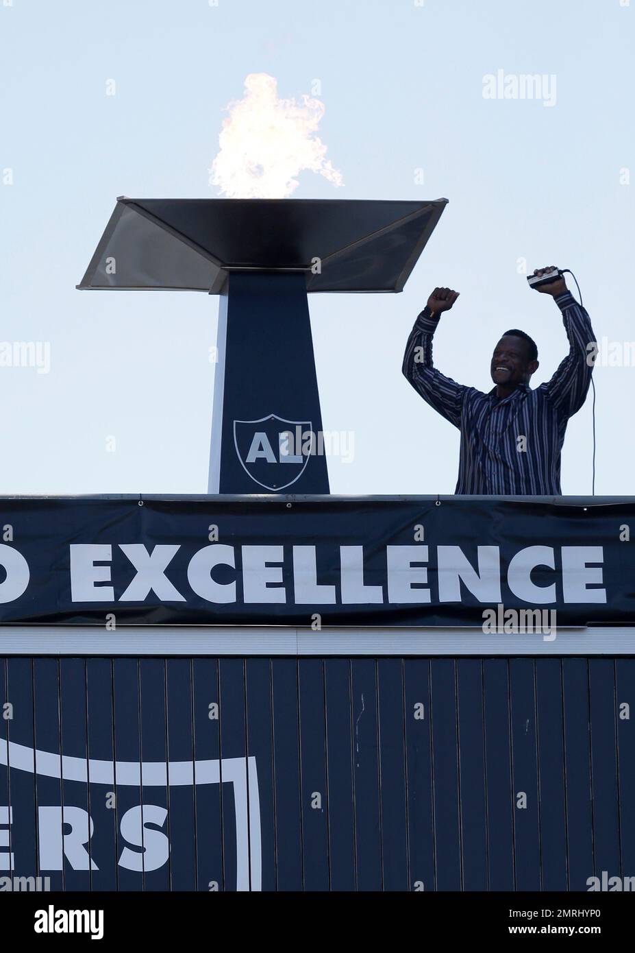 Former Oakland Athletic and Baseball Hall of Fame inductee Rickey Henderson gestures after lighting a ceremonial torch for former Oakland Raiders owner Al Davis before an NFL football game between the Oakland Raiders and the New York Jets in Oakland, Calif., Sunday, Sept. 17, 2017. (AP Photo/Ben Margot) Banque D'Images