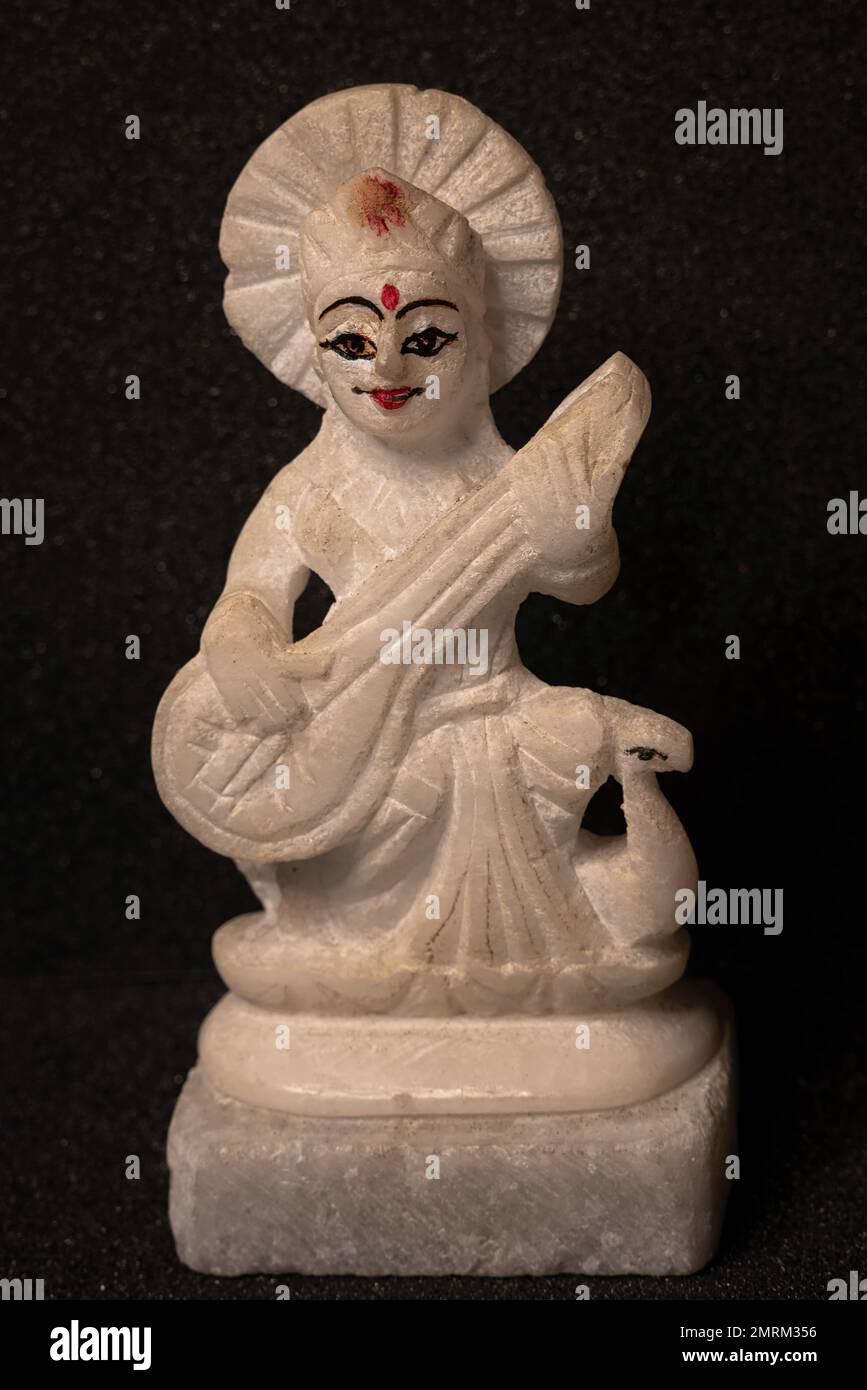 Gros plan de la déesse Saraswati idol fait de pierre blanche isolée sur fond noir, devi Saraswati considéré comme la déesse de la connaissance, mus Banque D'Images