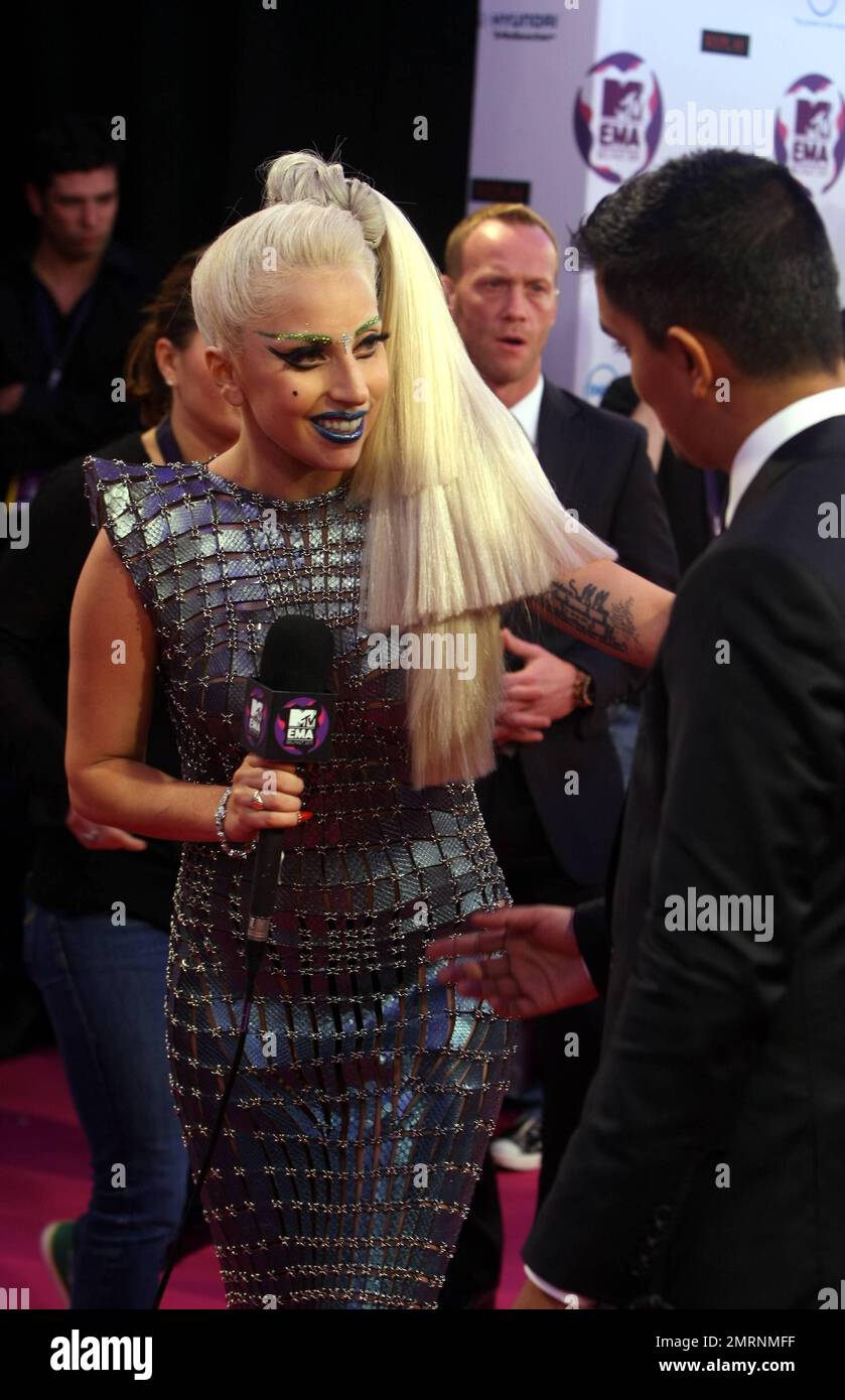 Dans une tenue tendance typique ornée d'sourcils verts étincelants, d'une croix argentée au-dessus de son nez, d'un rouge à lèvres bleu et d'une coiffure multi-couches, Lady Gaga présente ses multiples récompenses remportées aux MTV Europe Music Awards 2011 à l'Odyssey Arena de Belfast, en Irlande du Nord. 6th novembre 2011. . Banque D'Images