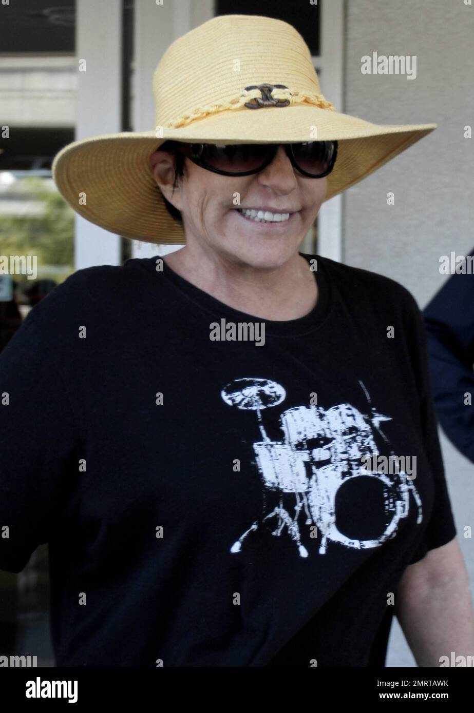 Ne portant aucun maquillage, la chanteuse légendaire Liza Minnelli porte un  grand chapeau de disquettes et des lunettes de soleil noires, accompagnées  d'un t-shirt noir et d'un pantalon noir lorsqu'elle arrive à