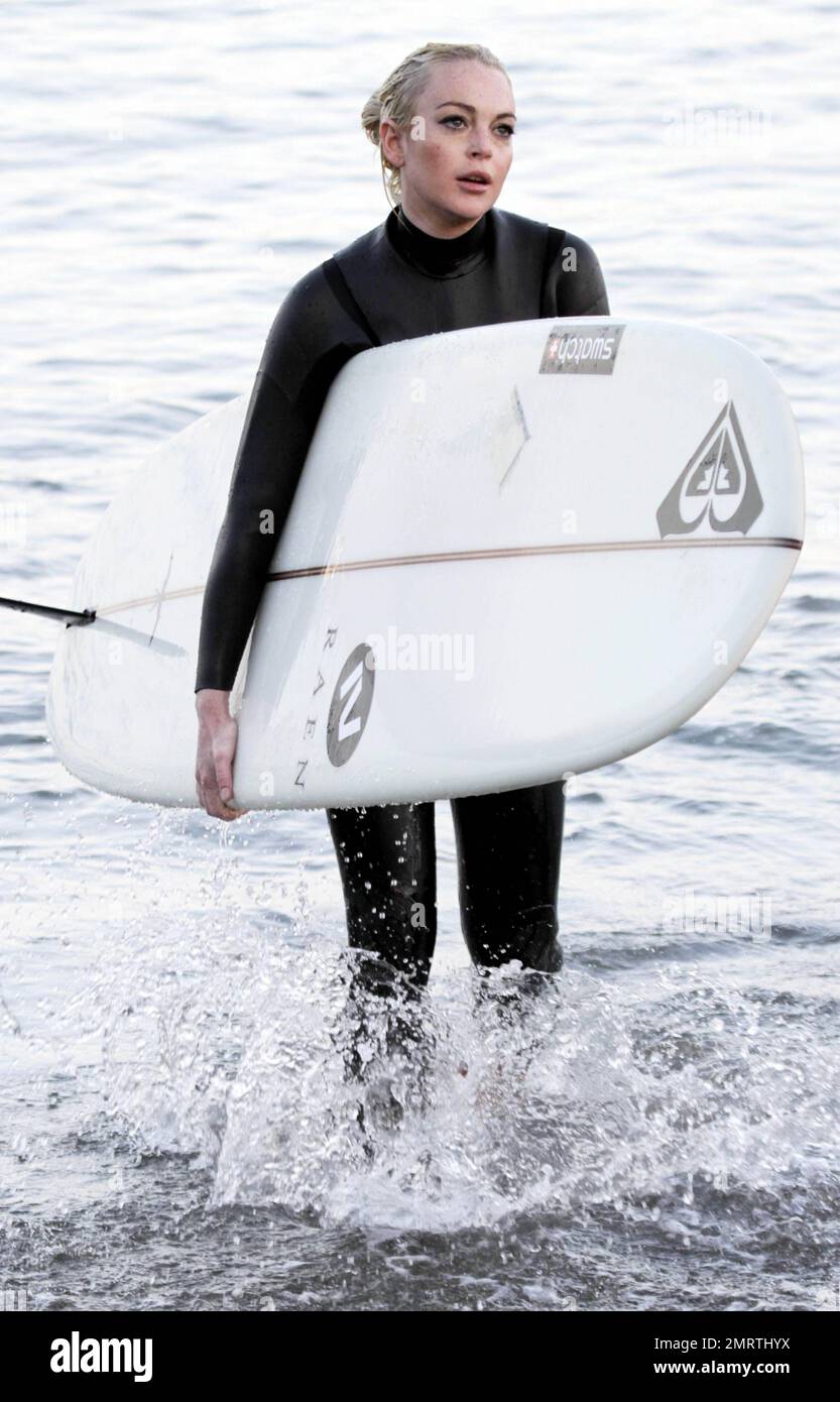 Lindsay Lohan tire quelques visages drôles tout en apprenant à surfer. Portant une combinaison noire, Lohan a tiré ses longs cheveux blonds dans un petit pain et a sauté dans les vagues avec une longue planche. Bien qu'il ait essuyé plusieurs fois, Lohan semblait passer un excellent moment. Malibu, Californie 16 août 2011. Banque D'Images