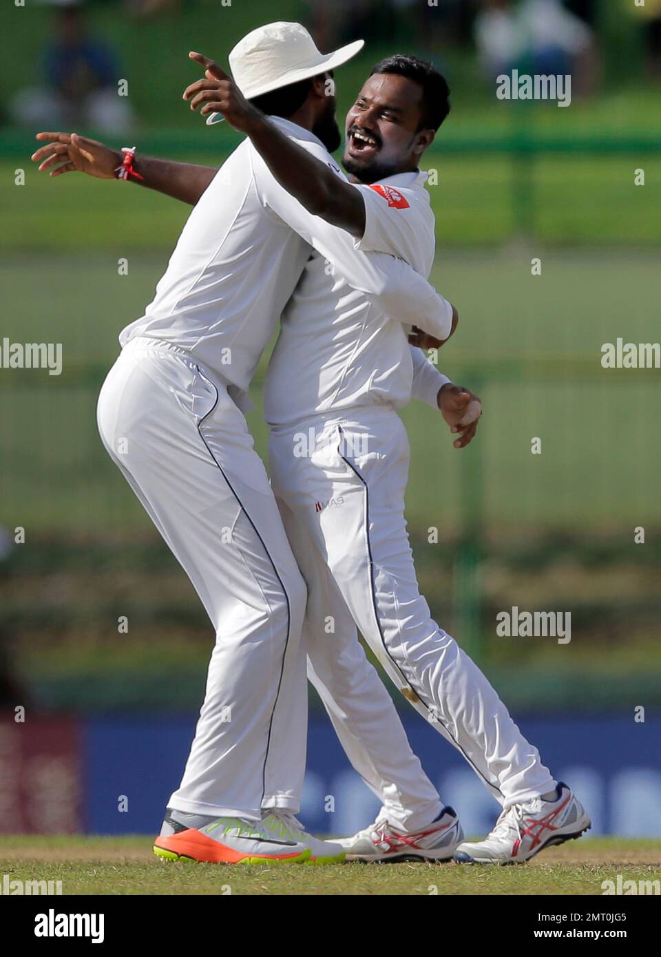 Sri Lanka's Malinda Pushpakumara, right, celebrates with captain Dinesh Chandimal the dismissal of India's Ajinkya Rahane during the first day's play of their third cricket test match in Pallekele, Sri Lanka, Saturday, Aug. 12, 2017. (AP Photo/Eranga Jayawardena) Banque D'Images