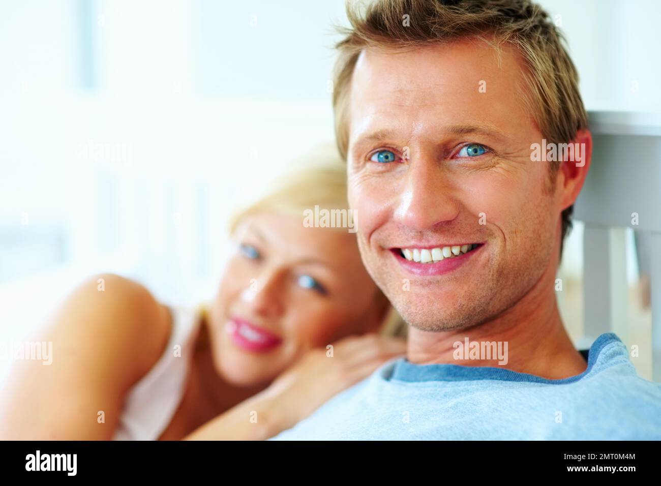 Homme d'âge moyen souriant avec une femme floue. Gros plan d'un homme d'âge moyen souriant avec une femme floue. Banque D'Images