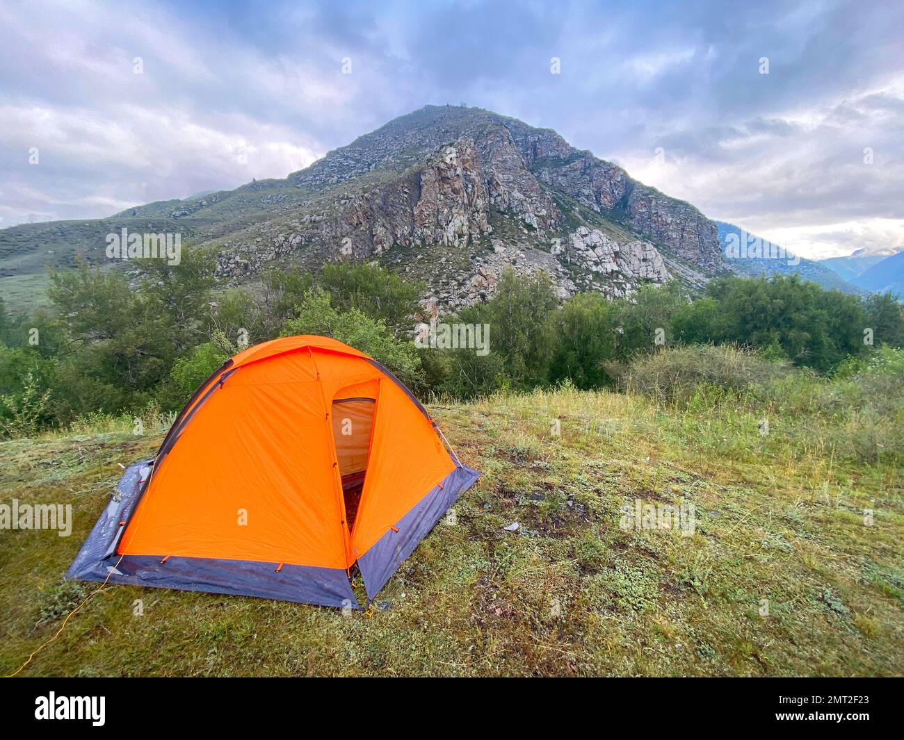 Entrée ouverte à une tente touristique avec un sac de couchage sur le fond de la montagne. Banque D'Images