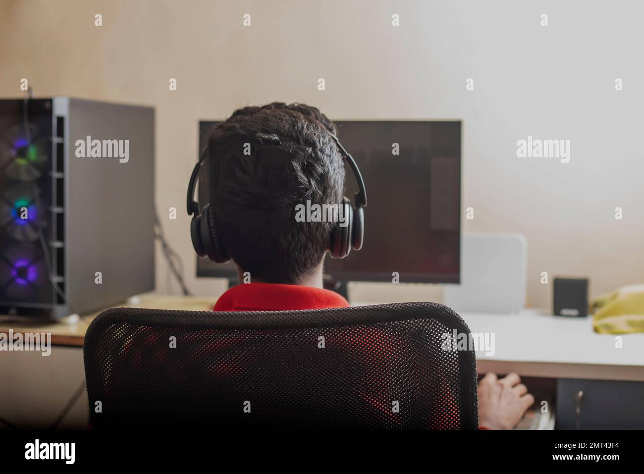 Un joueur jouant à un jeu vidéo en ligne sur son ordinateur personnel puissant - tourné de l'arrière Banque D'Images