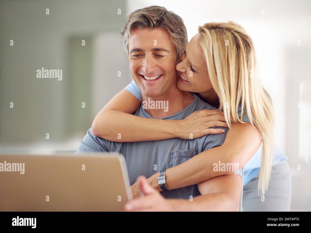 Profiter de leur vie sans fil. un couple heureux et mature utilisant un ordinateur portable à la maison. Banque D'Images