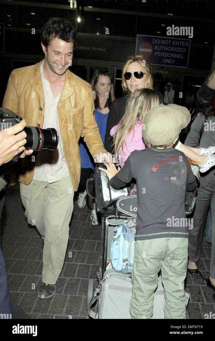 Noah Wylie, la star « ER », et la famille arrivent au bord de l'État à l'aéroport international de Los Angeles après des vacances européennes en famille. Noé et son épouse Tracy Warbin ont transporté leurs enfants, leur fille Auden et leur fils Owen Strausser à travers l'aéroport, car ils ont été aidés avec leurs bagages. Les enfants avaient l'air fatigués après le long vol. Los Angeles, Californie. 4/29/09. Banque D'Images