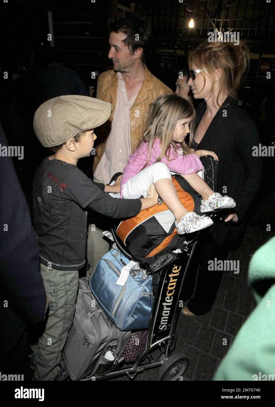 Noah Wylie, la star « ER », et la famille arrivent au bord de l'État à l'aéroport international de Los Angeles après des vacances européennes en famille. Noé et son épouse Tracy Warbin ont transporté leurs enfants, leur fille Auden et leur fils Owen Strausser à travers l'aéroport, car ils ont été aidés avec leurs bagages. Les enfants avaient l'air fatigués après le long vol. Los Angeles, Californie. 4/29/09. Banque D'Images