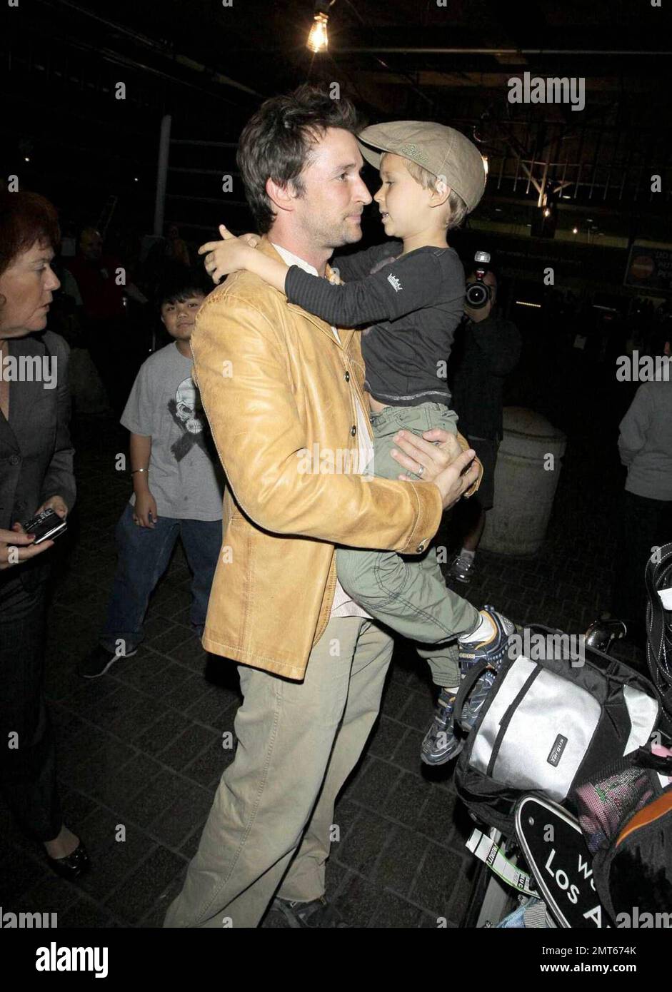 Noah Wylie, la star « ER », et la famille arrivent au bord de l'État à l'aéroport international de Los Angeles après des vacances européennes en famille. Noé et son épouse Tracy Warbin ont transporté leurs enfants, leur fille Auden et leur fils Owen Strausser à travers l'aéroport, car ils ont été aidés avec leurs bagages. Les enfants avaient l'air fatigués après le long vol. Los Angeles, Californie. 4/29/09. Banque D'Images