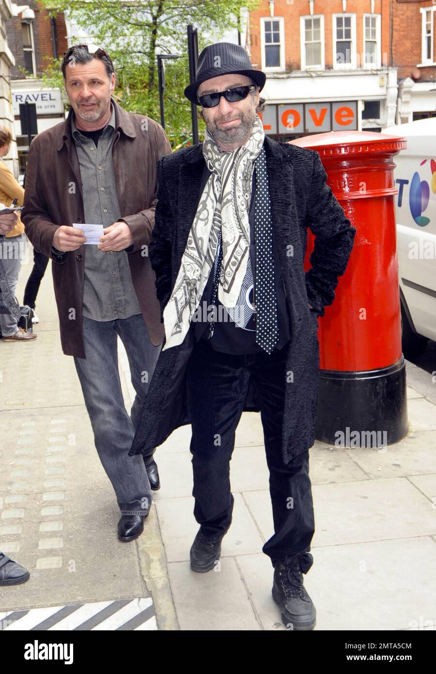 Le chanteur Paul Rodgers, connu pour son travail avec les groupes  légendaires Free, Bad Company et Now Queen, porte un foulard à motif  flamboyant et une cravate à pois noirs lorsqu'il pose