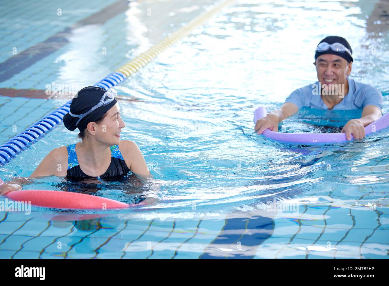 Couple senior japonais à la piscine intérieure Banque D'Images