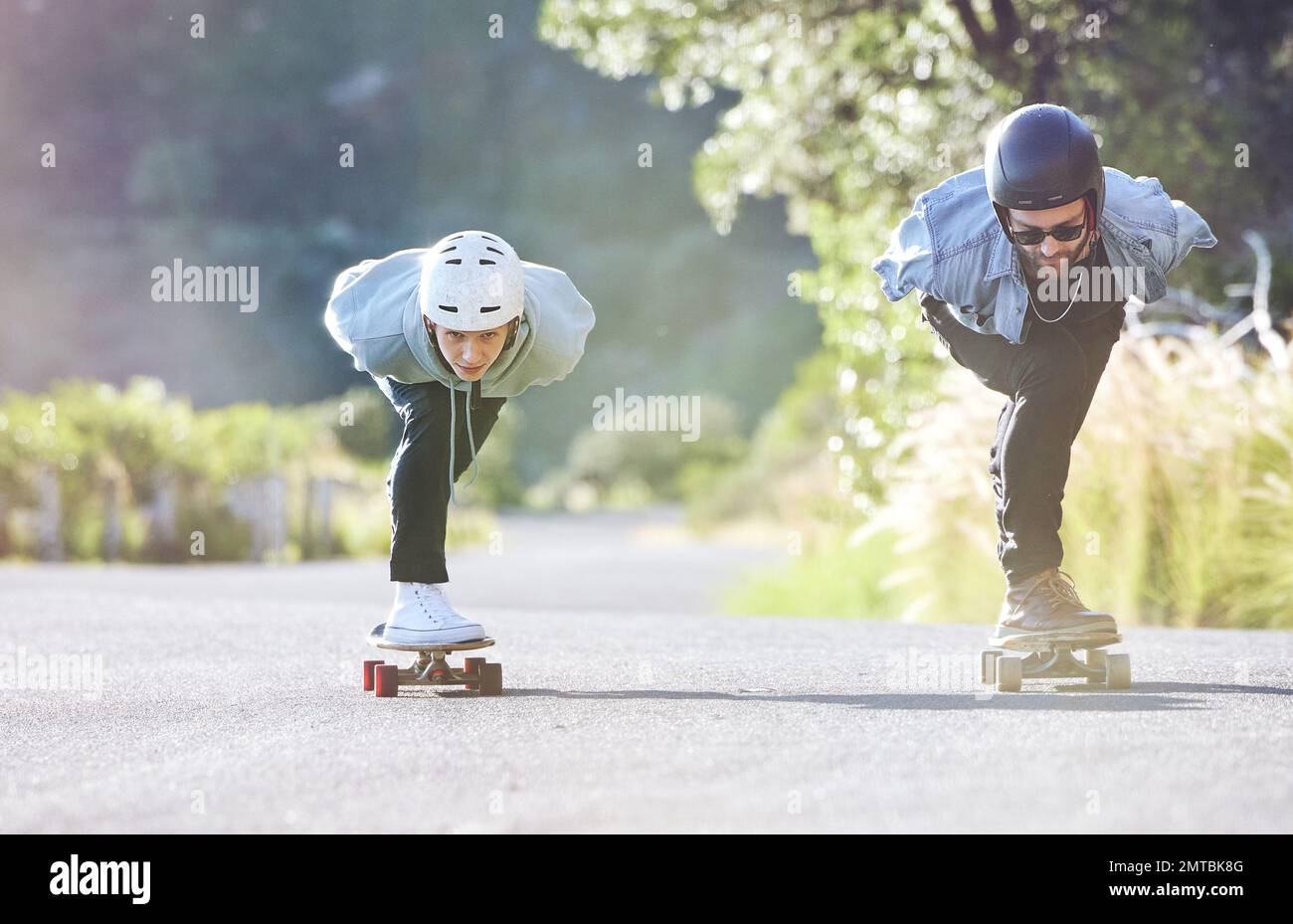 Amis, vitesse et patinage de longue durée sur route, course en descente avec skateboard et casque pour la sécurité. Aventure sportive extrême, skate Street Banque D'Images