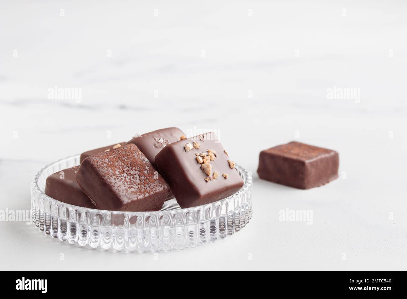 Bonbons au chocolat faits à la main avec praline sur fond blanc avec photo horizontale d'espace de copie Banque D'Images