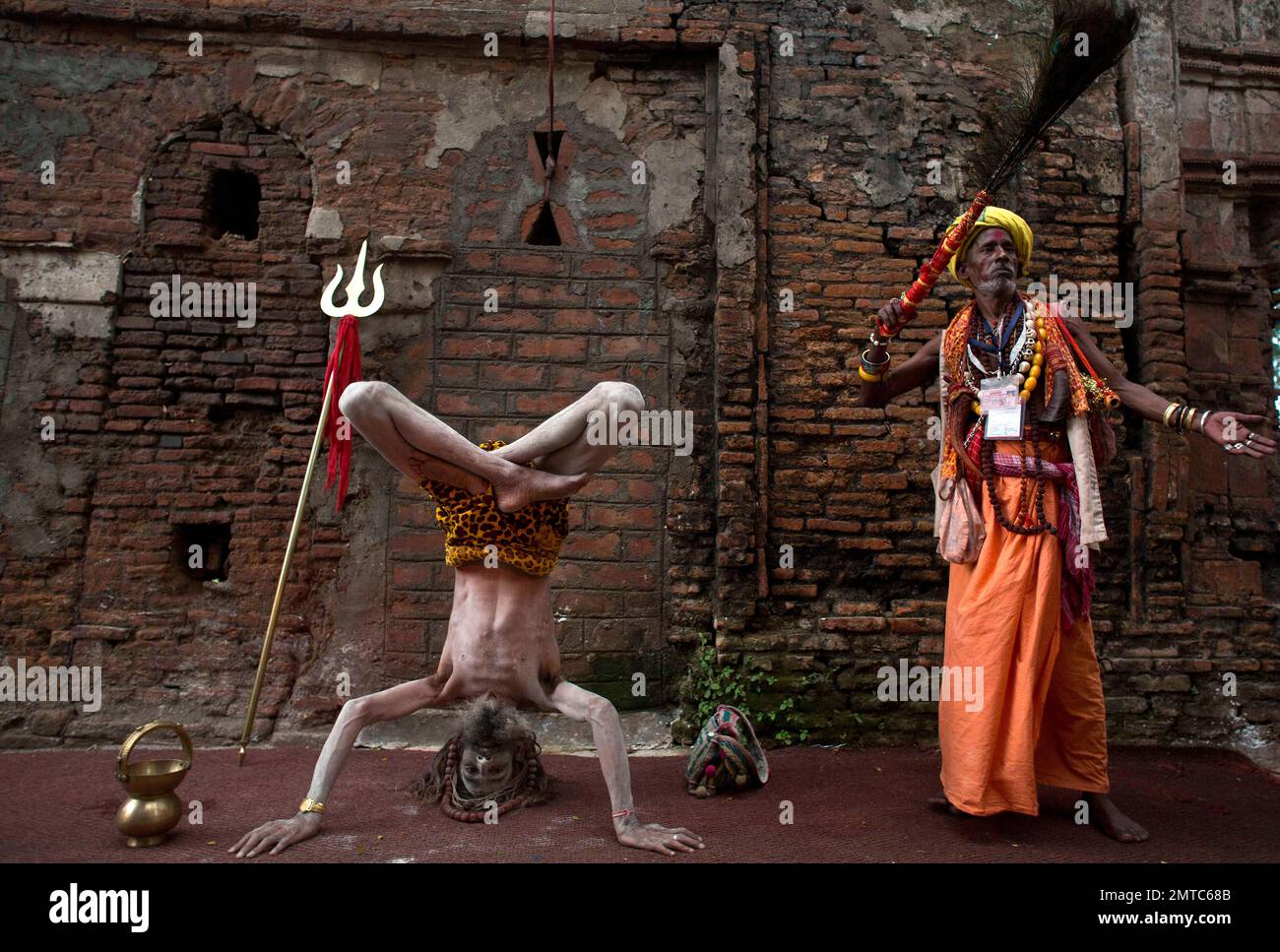 An Indian Sadhu or Hindu holy man, left, performs yoga at Kamakhya temple during the Ambubachi festival, in Gauhati India, Friday, June 23, 2017. Hundreds of Hindu holy men have arrived to perform rituals at the temple during the four day long festival that started Thursday. (AP Photo/ Anupam Nath) Banque D'Images
