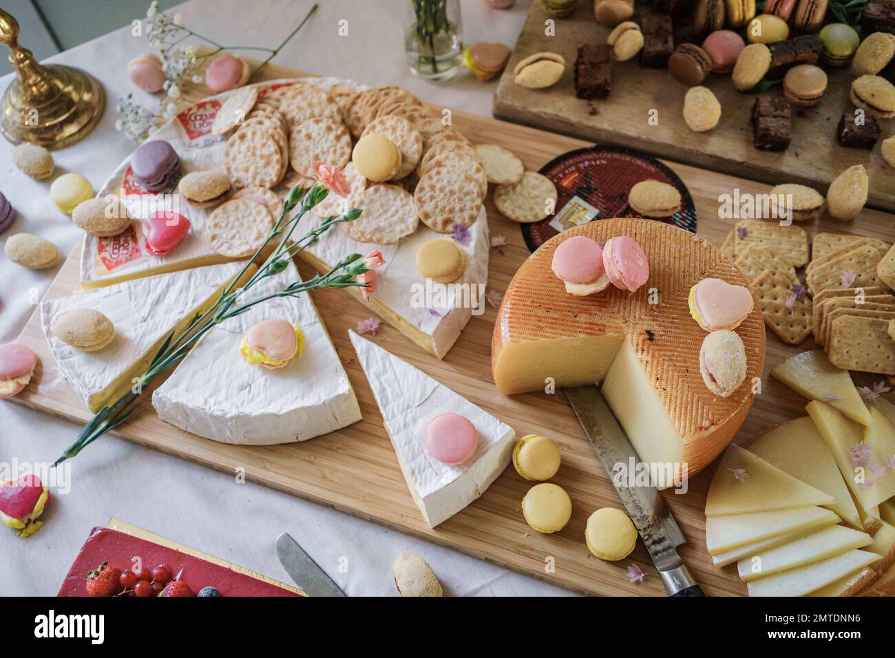 Fromages et macarons sur la table, bar à bonbons de mariage de luxe. ROSE BLUSH NATURE MORTE Banque D'Images