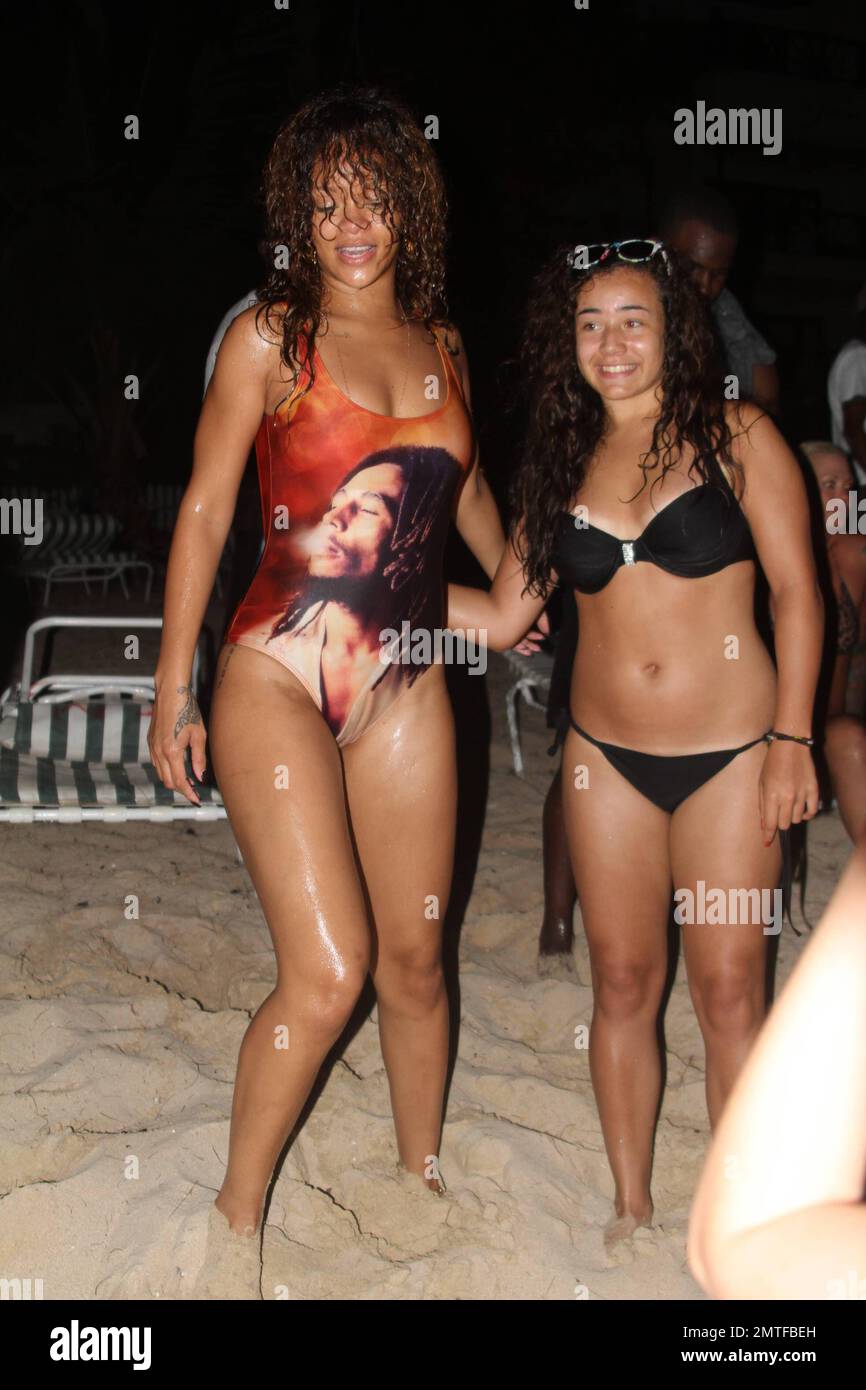 Rihanna portant un maillot de bain Bob Marley d'une pièce, nagé à la rive à partir d'un yacht et a dit à un barman de plage qu'il avait '3 minutes pour lui obtenir une bière'. Elle a posé pour des photos avec des fans avant de sauter sur un petit bateau qui l'a ramenée au yacht, Barbade, 6th août 2011. Banque D'Images Rihanna portant un maillot de bain Bob Marley d'une pièce, nagé à la rive à partir d'un yacht et a dit à un barman de plage qu'il avait '3 minutes pour lui obtenir une bière'. Elle a posé pour des photos avec des fans avant de sauter sur un petit bateau qui l'a ramenée au yacht, Barbade, 6th août 2011. Banque D'Images